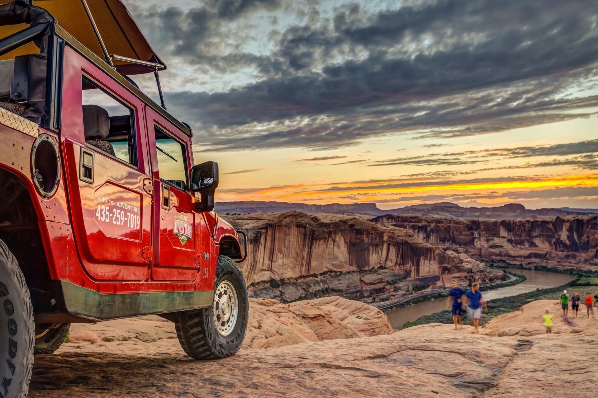 A red Hummer overlooking the Colorado River at sunset