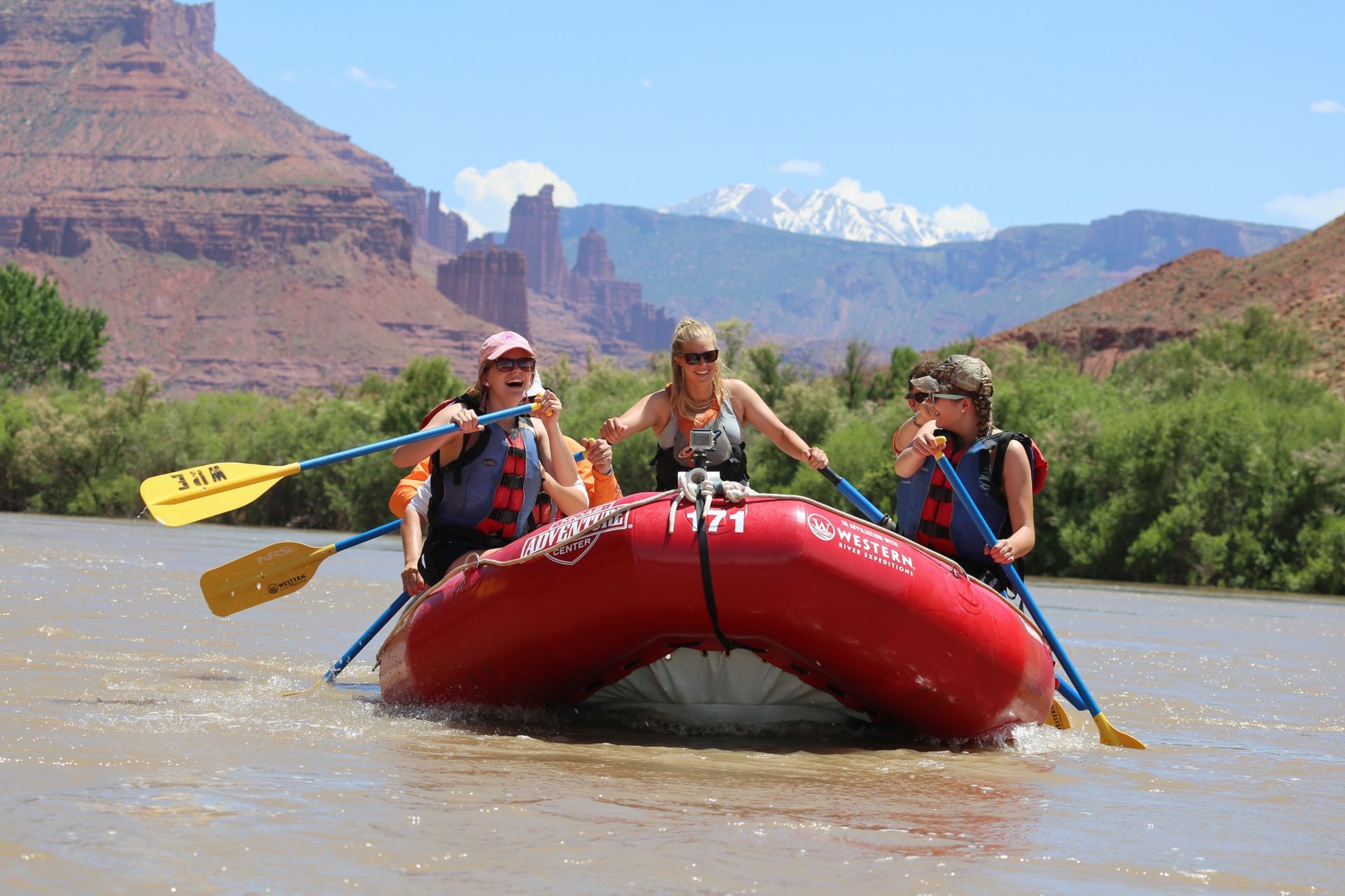 Paddlers float on calm water with mountains behind them