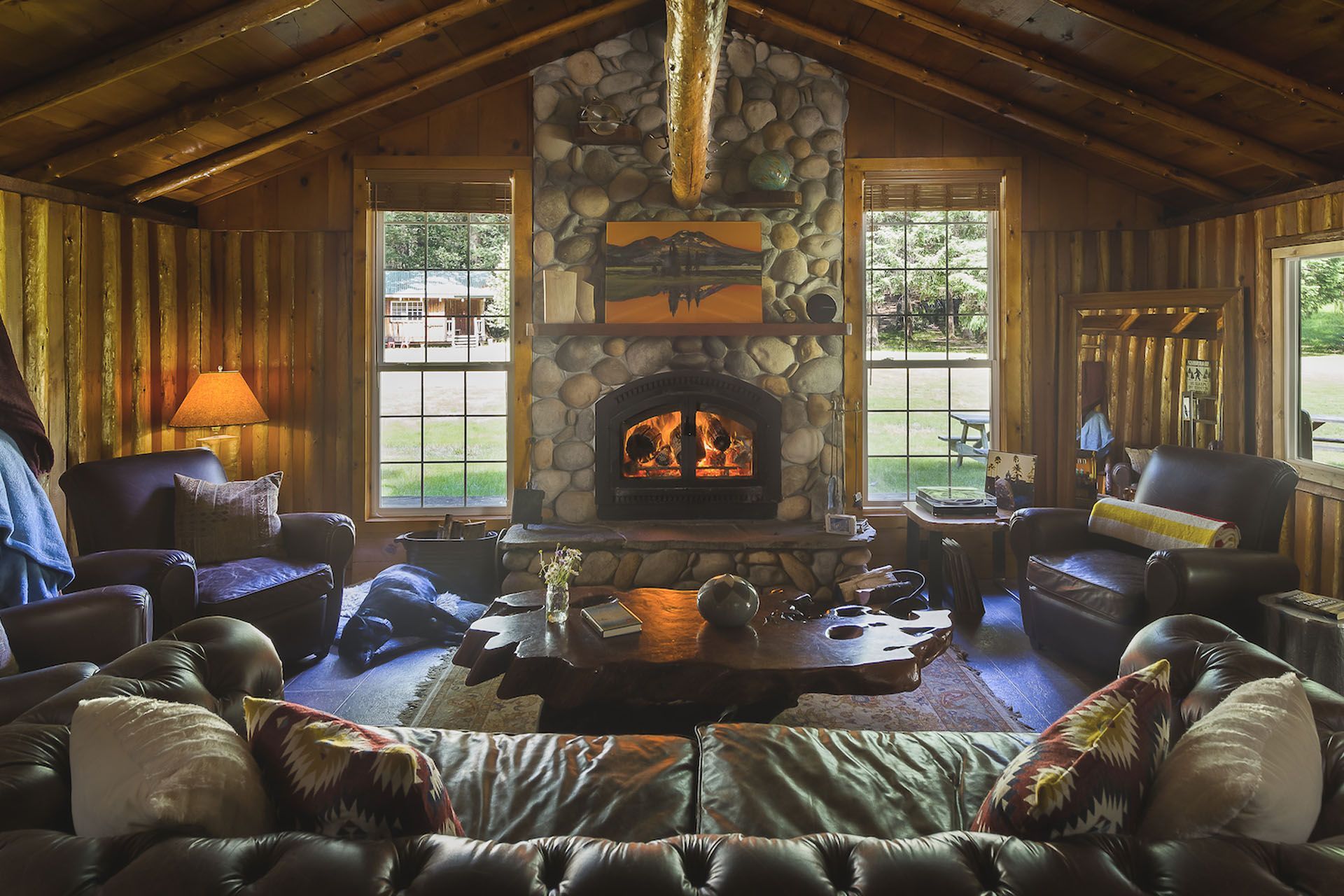 Sofas and a stone fireplace inside Half Moon Bar Lodge