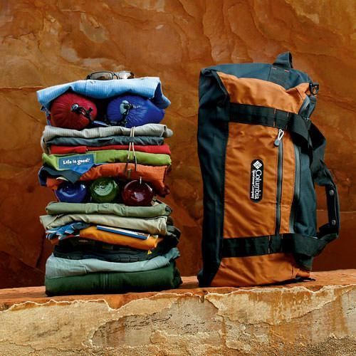 Stack of clothing next to a duffle bag