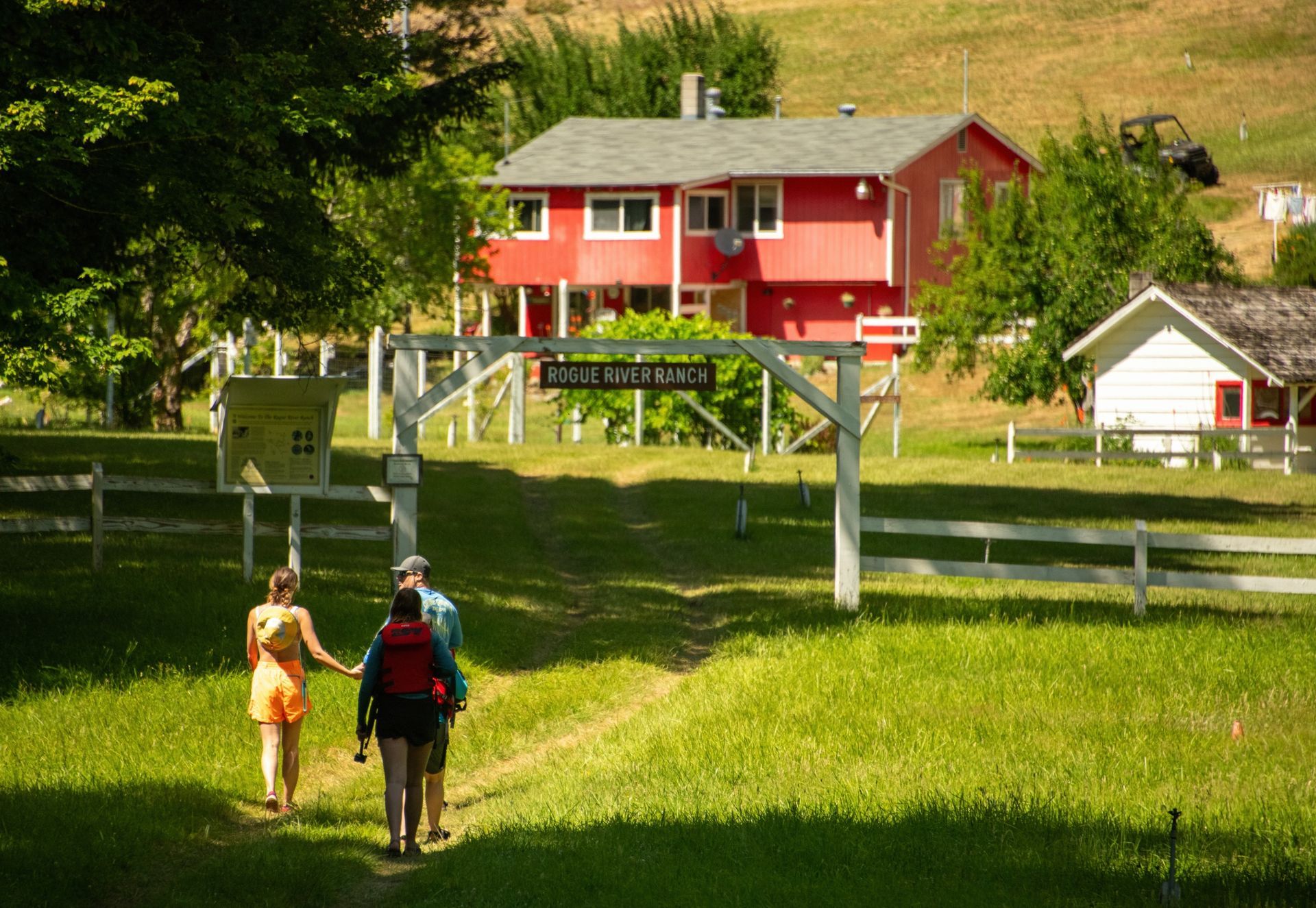 Guests walk toward a red lodge building across a lawn