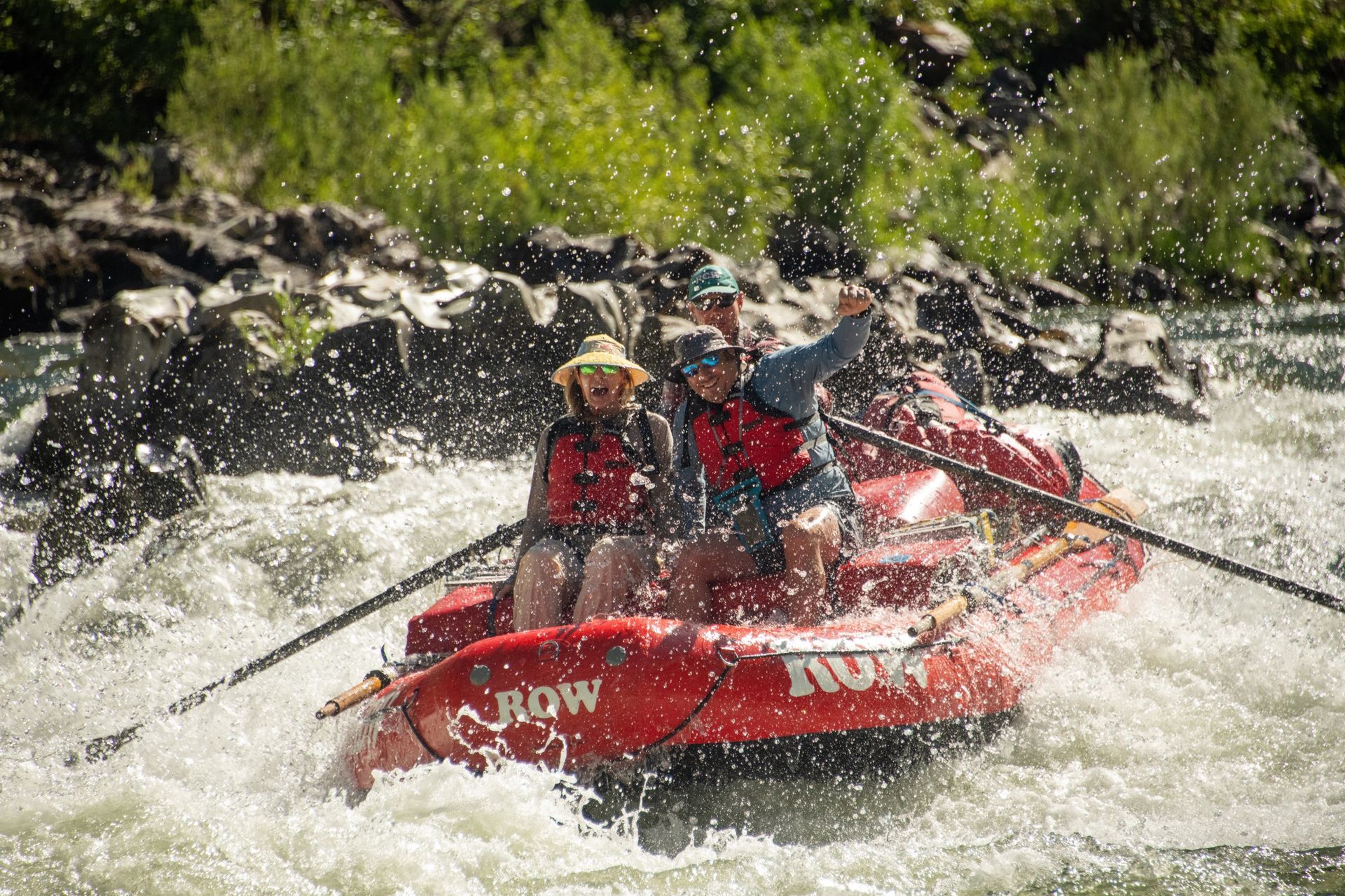 Guide rowing an oar boat through Rogue River whitewater