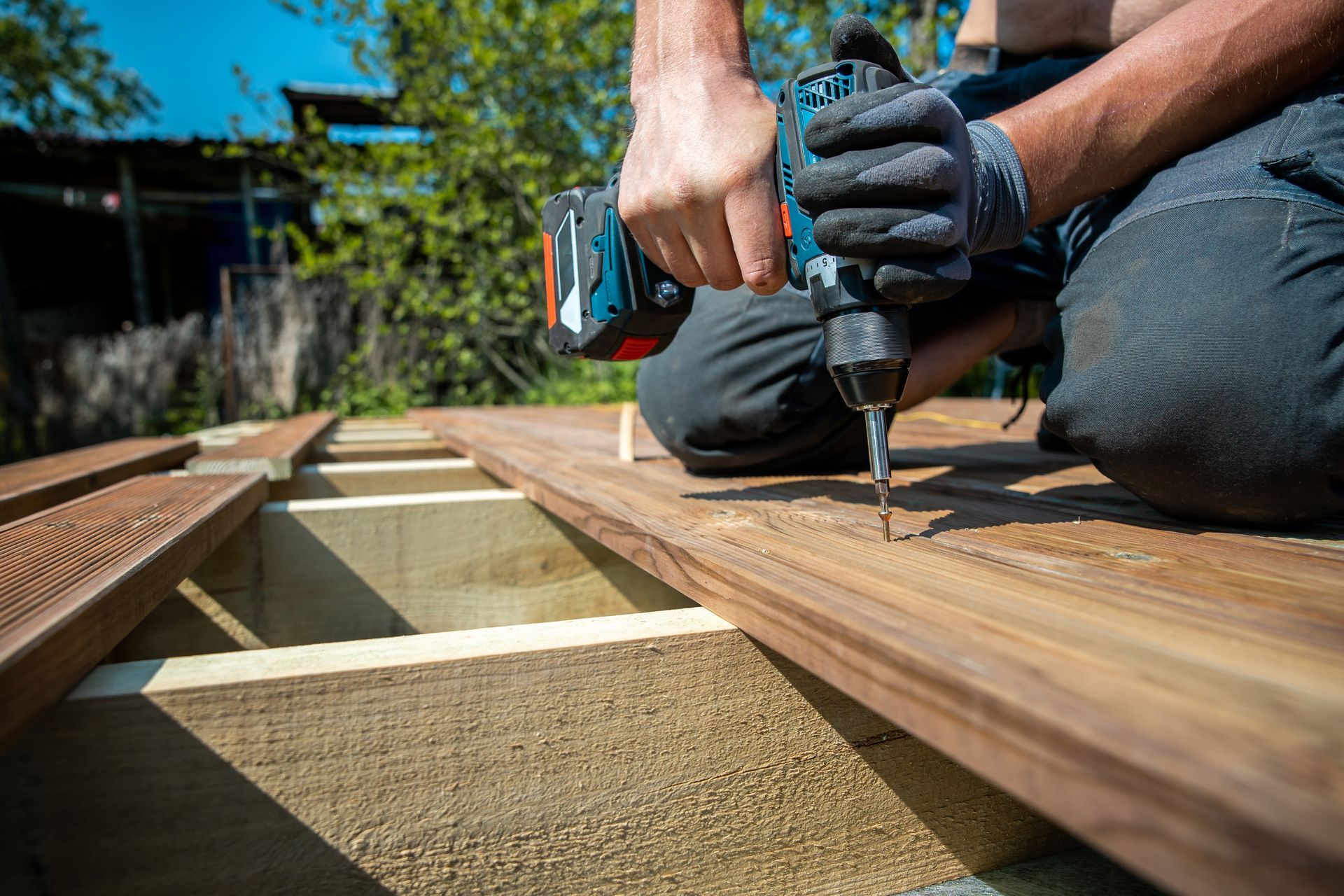 A man is using a drill to drill a hole in a piece of wood.