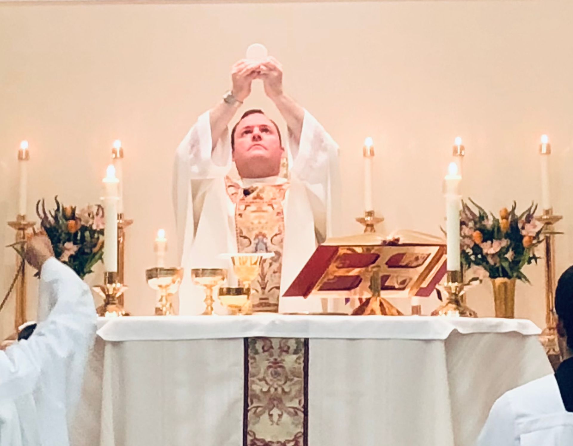 priest at the altar with raised hands