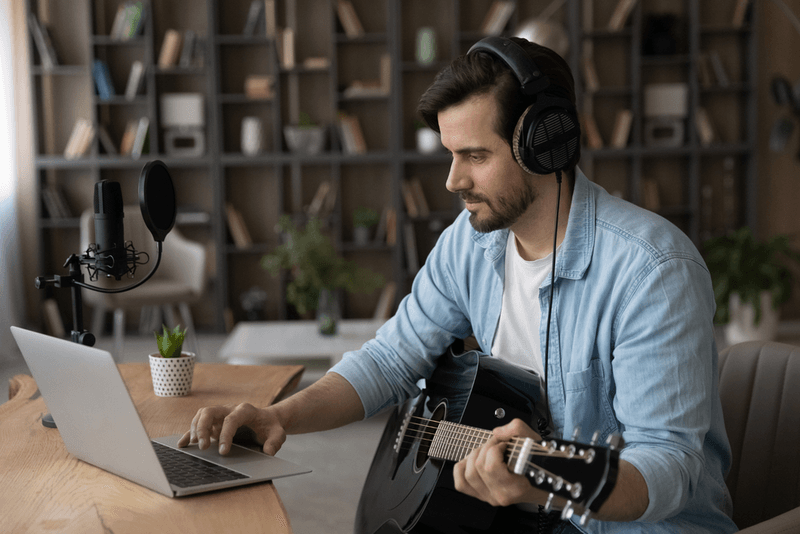man_met _gitaar_en _laptop