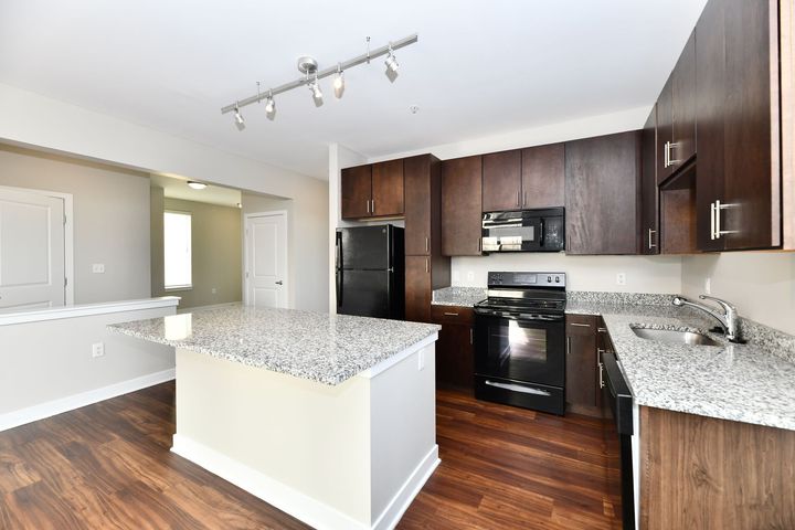 An empty apartment with hardwood floors and white walls.