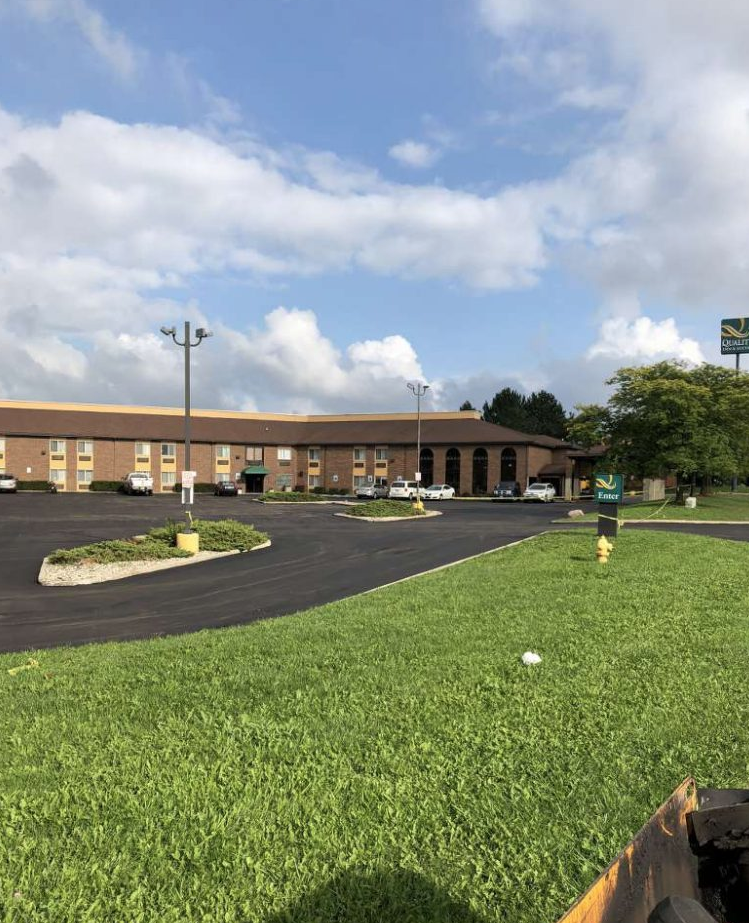 A large building with a lot of cars parked in front of it.