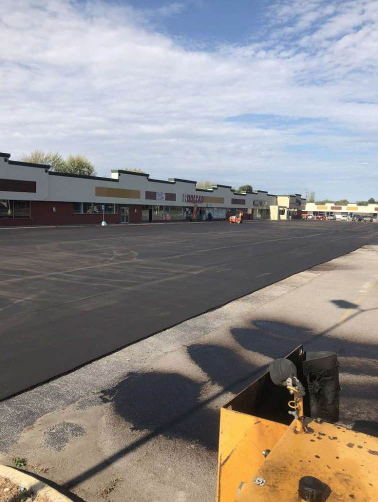 An empty parking lot with a building in the background