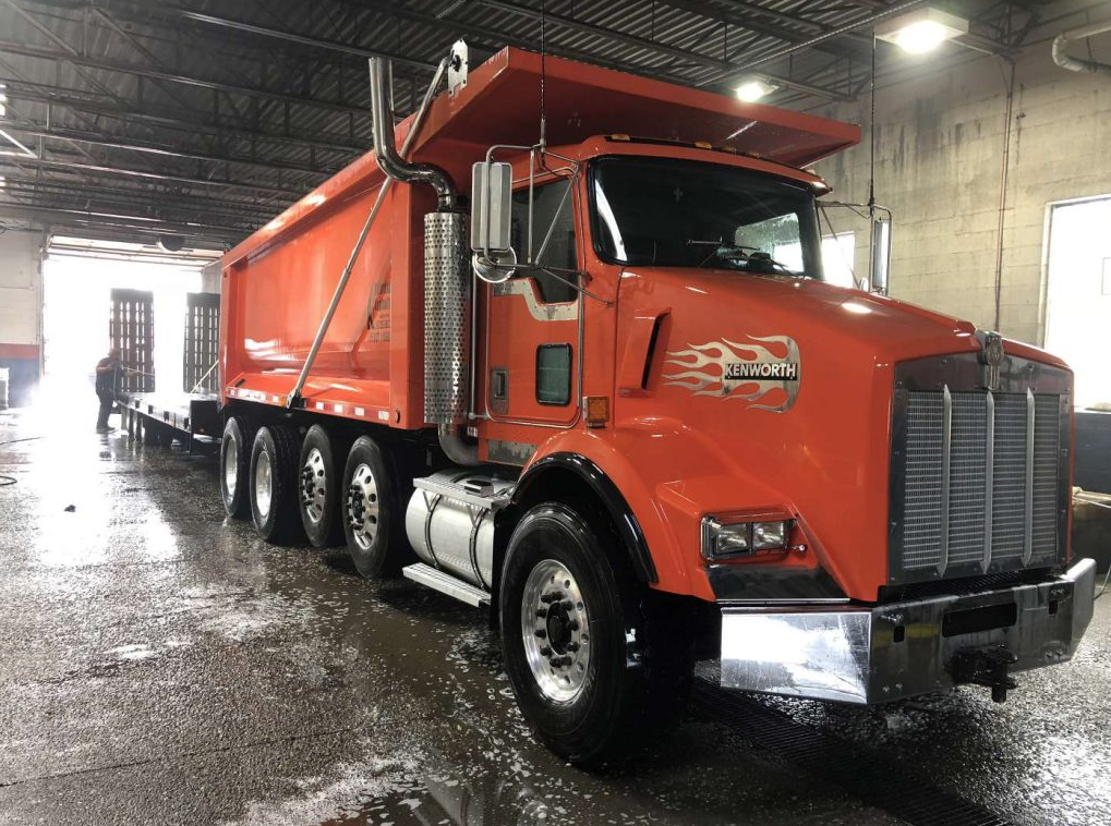 A red dump truck is parked in a garage.