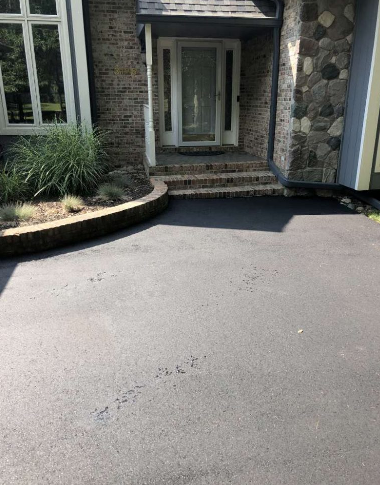 A brick house with a driveway in front of it