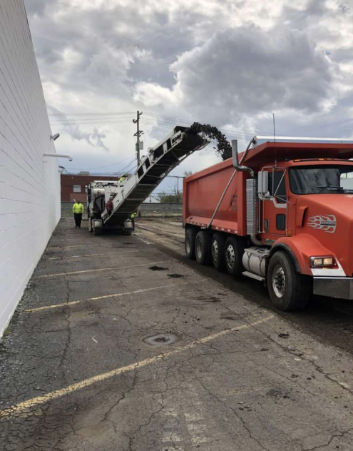 A red dump truck is parked in a parking lot