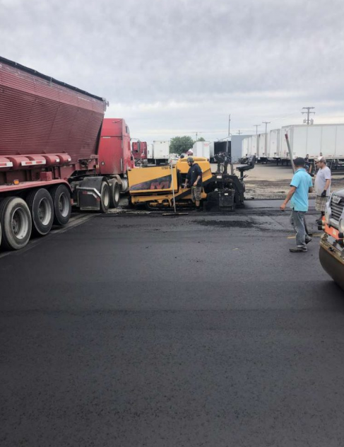 A red truck is parked next to a yellow tractor