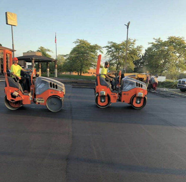 A couple of orange vehicles are driving down a road