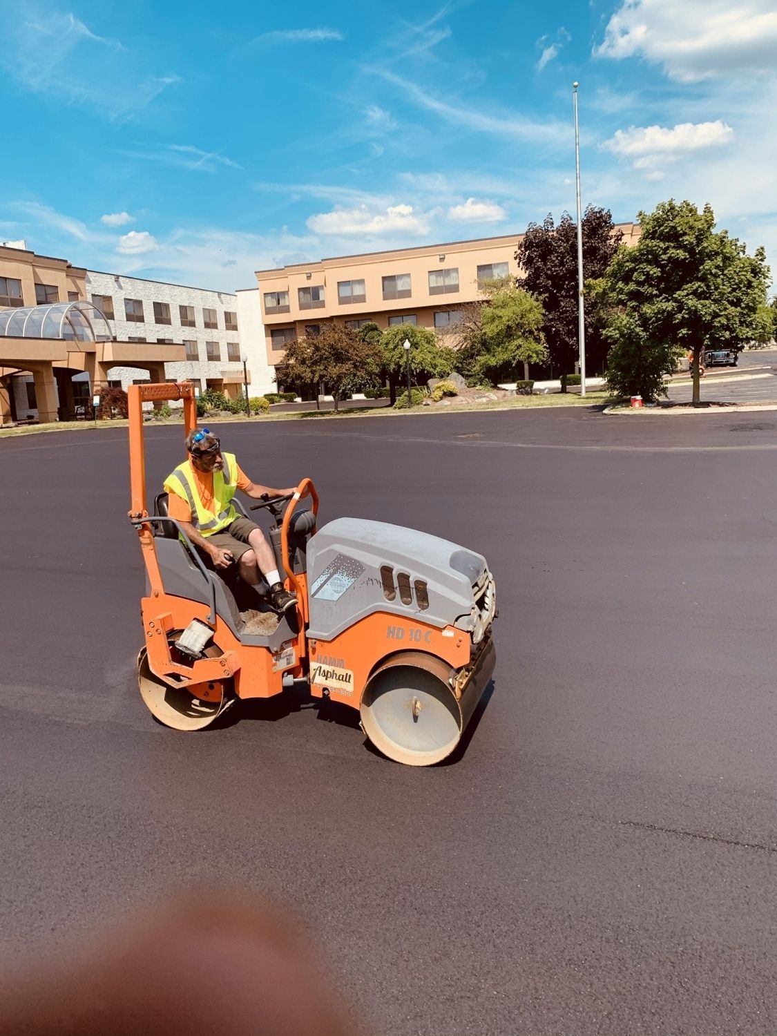 A man is driving a roller on a road.