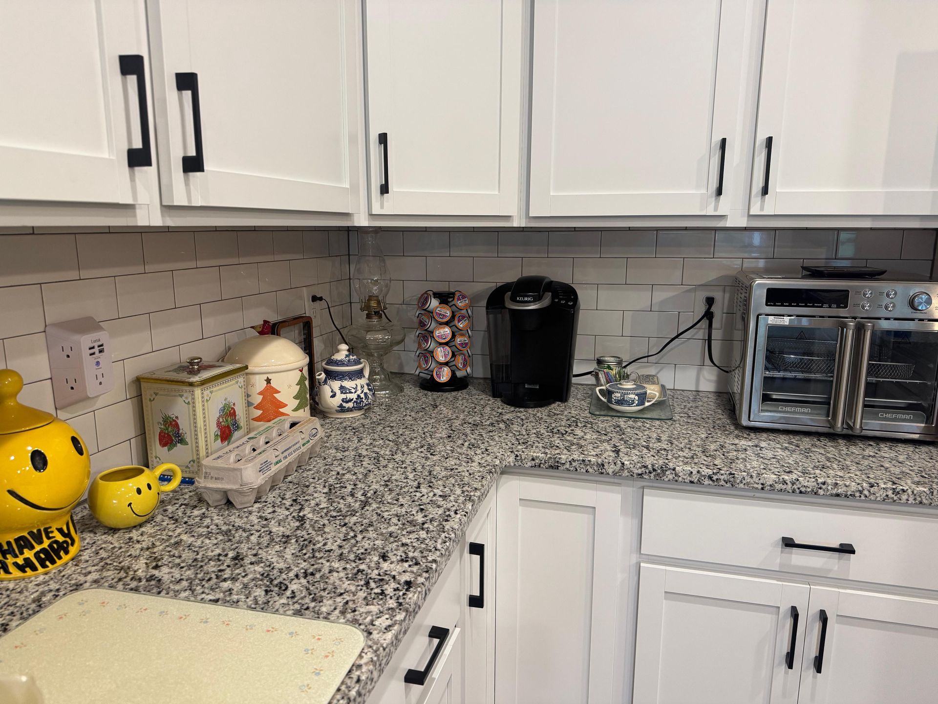 Kitchen counter with white cabinets, granite countertop, coffee maker, toaster oven, and Halloween decorations. Kitchen counter with white cabinets, granite countertop, coffee maker, toaster oven, and Halloween decorations.