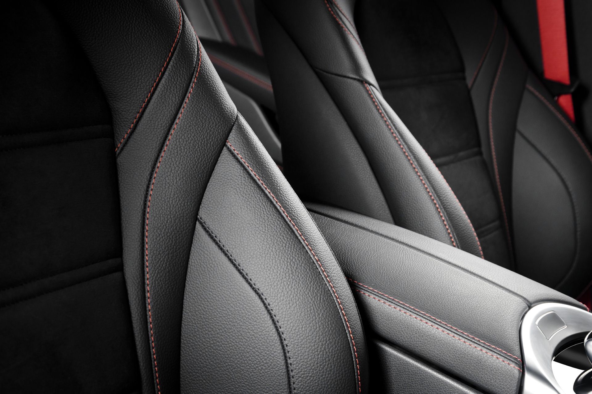Close-up of black and gray car seats with red stitching and carbon-fiber trim