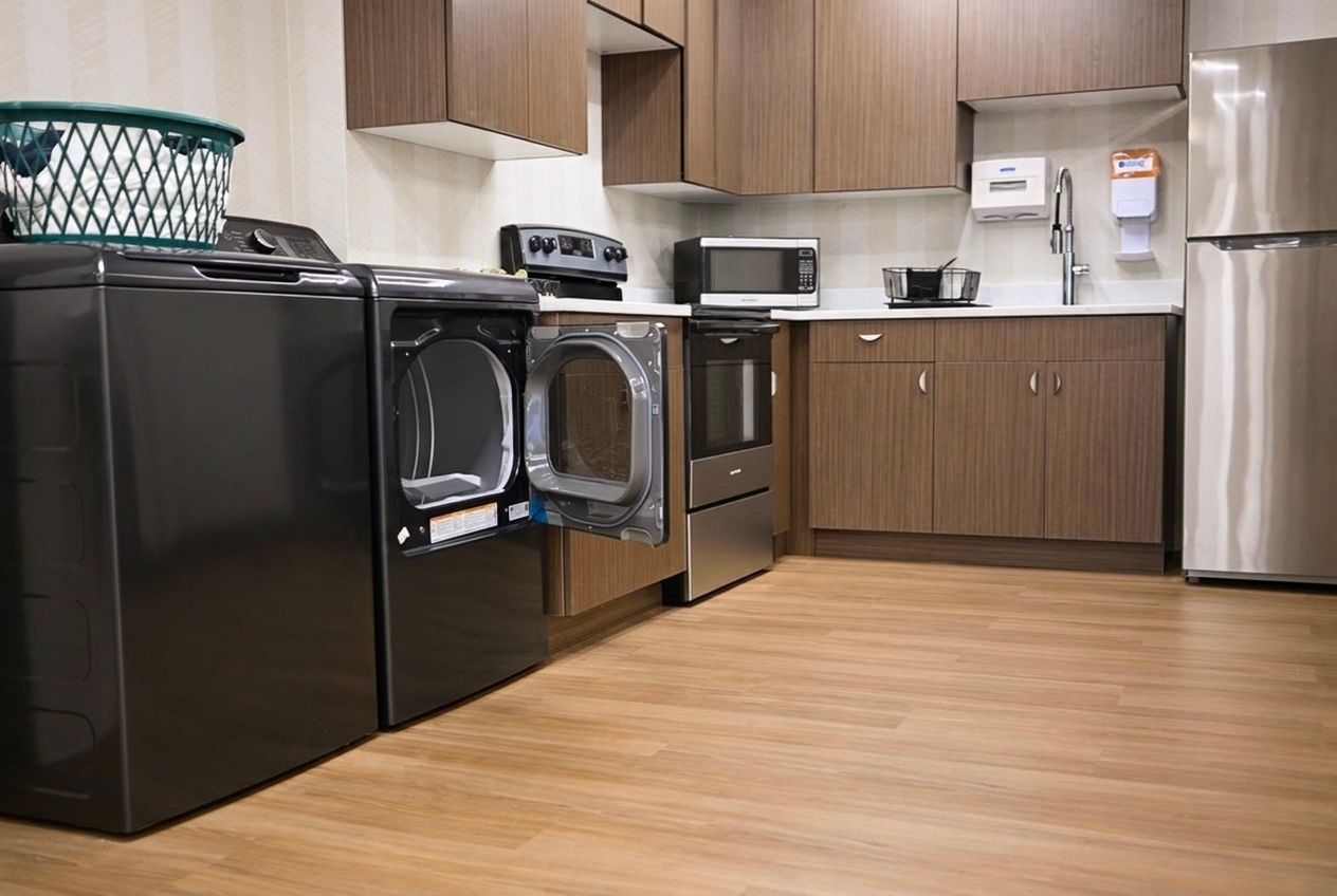 Modern kitchen with black appliances, wood cabinets, and a light wood floor
