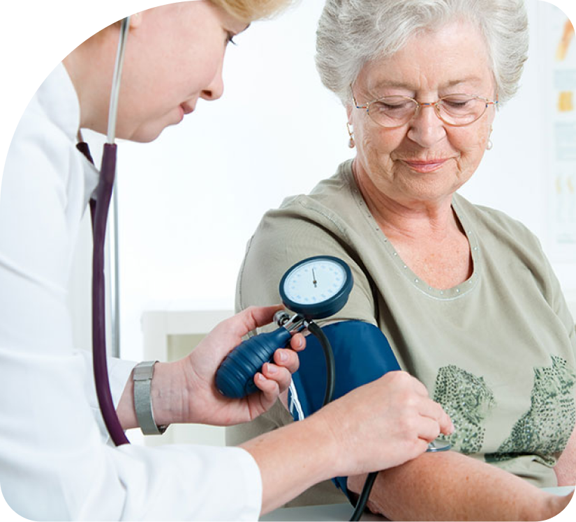 Doctor taking blood pressure of a seated patient in a bright clinic room