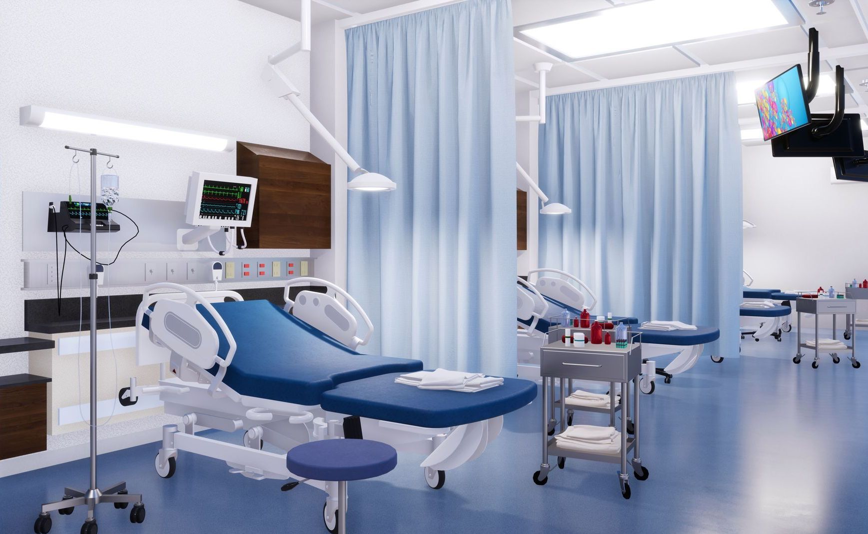 Modern hospital ward with blue patient beds, privacy curtains, and monitoring equipment