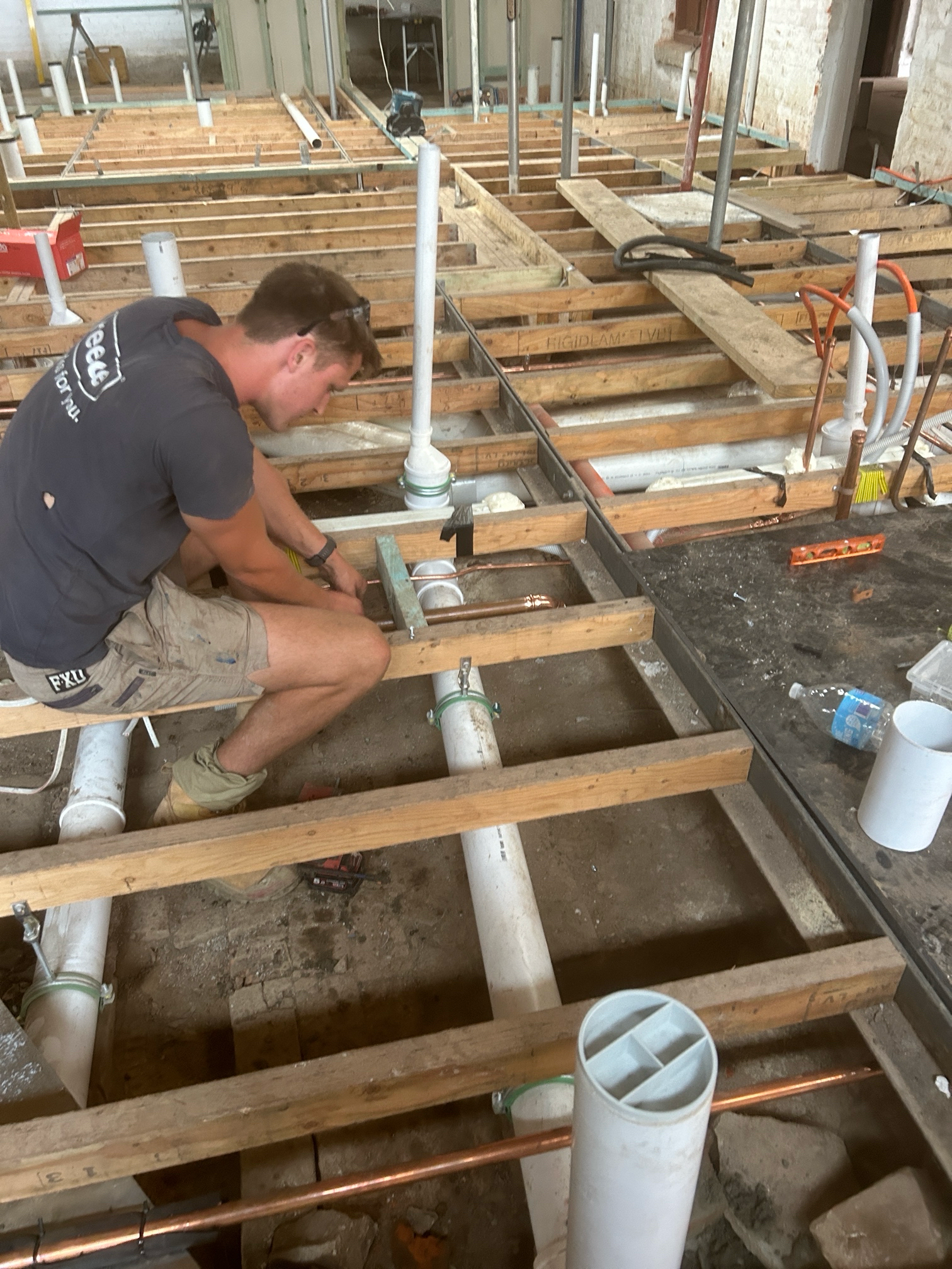 Man Installing Plumbing in a Building Under Construction — Croker Plumbing and Gas in Goulburn, NSW