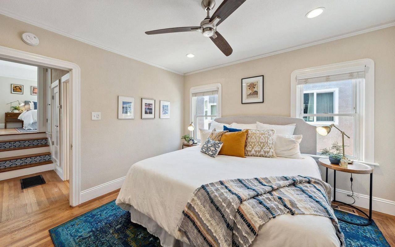 A bedroom with a large bed and a ceiling fan.