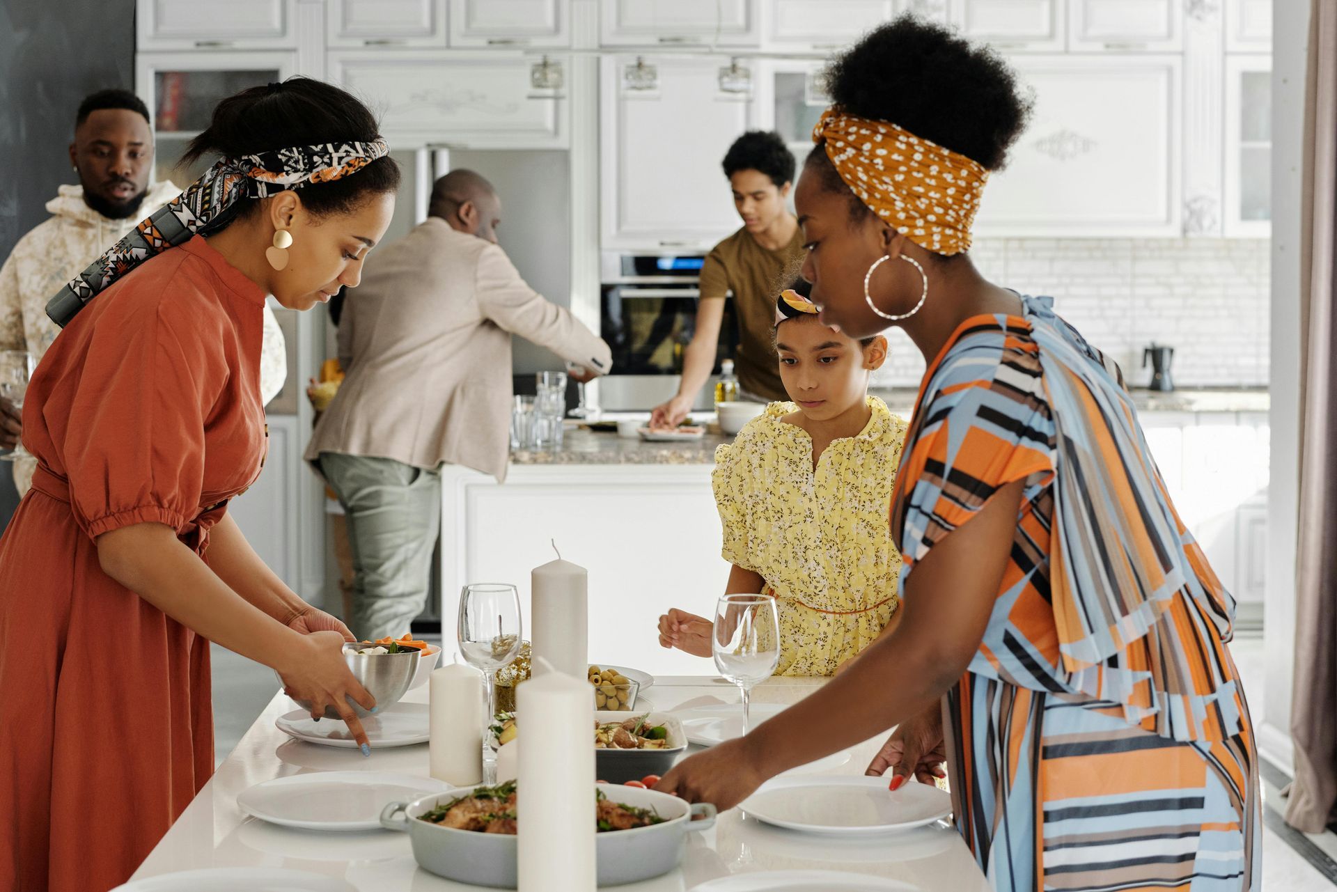 A group of people are standing around a table preparing food.