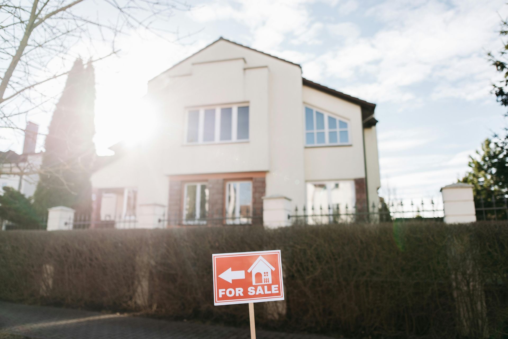 A house with a for sale sign in front of it.