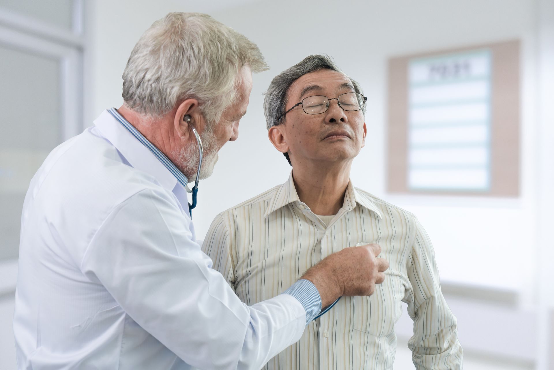 Doctor examining a patient’s chest in a bright clinic