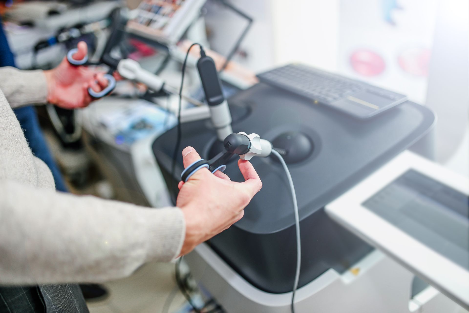 Hands using a handheld controller beside medical equipment in a bright lab or clinic setting Hands using a handheld controller beside medical equipment in a bright lab or clinic setting