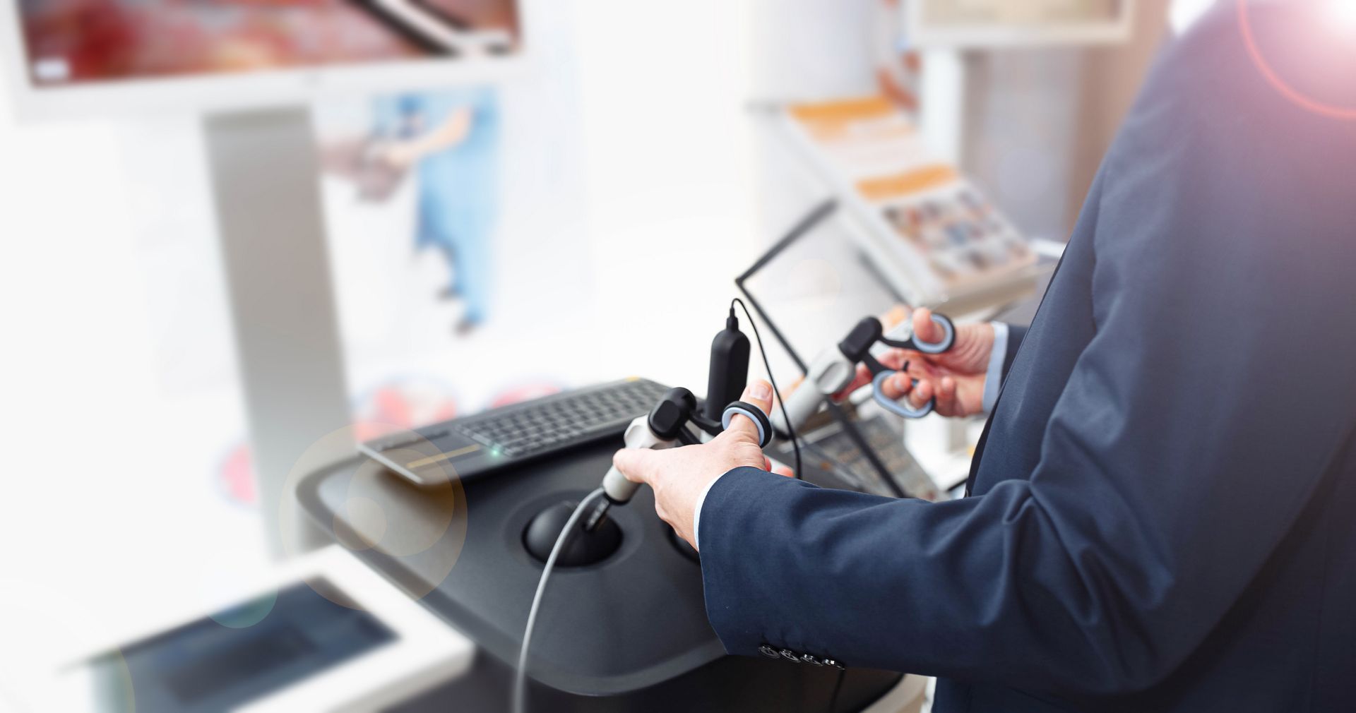 Person in a navy suit using a handheld device at a desk in a bright office Person in a navy suit using a handheld device at a desk in a bright office