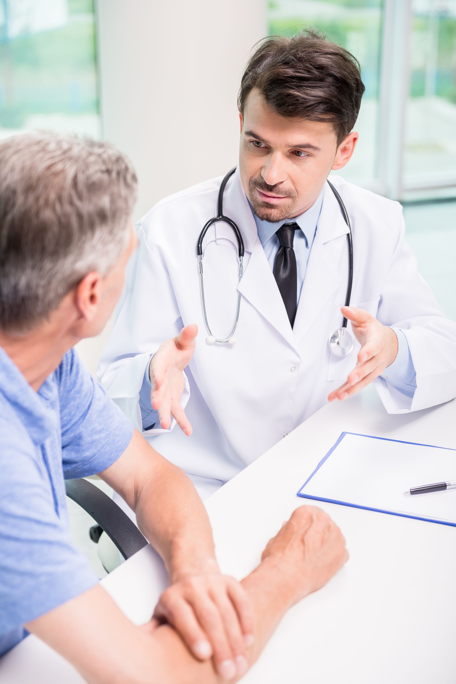 Doctor in white coat speaking with a patient in a bright clinic office