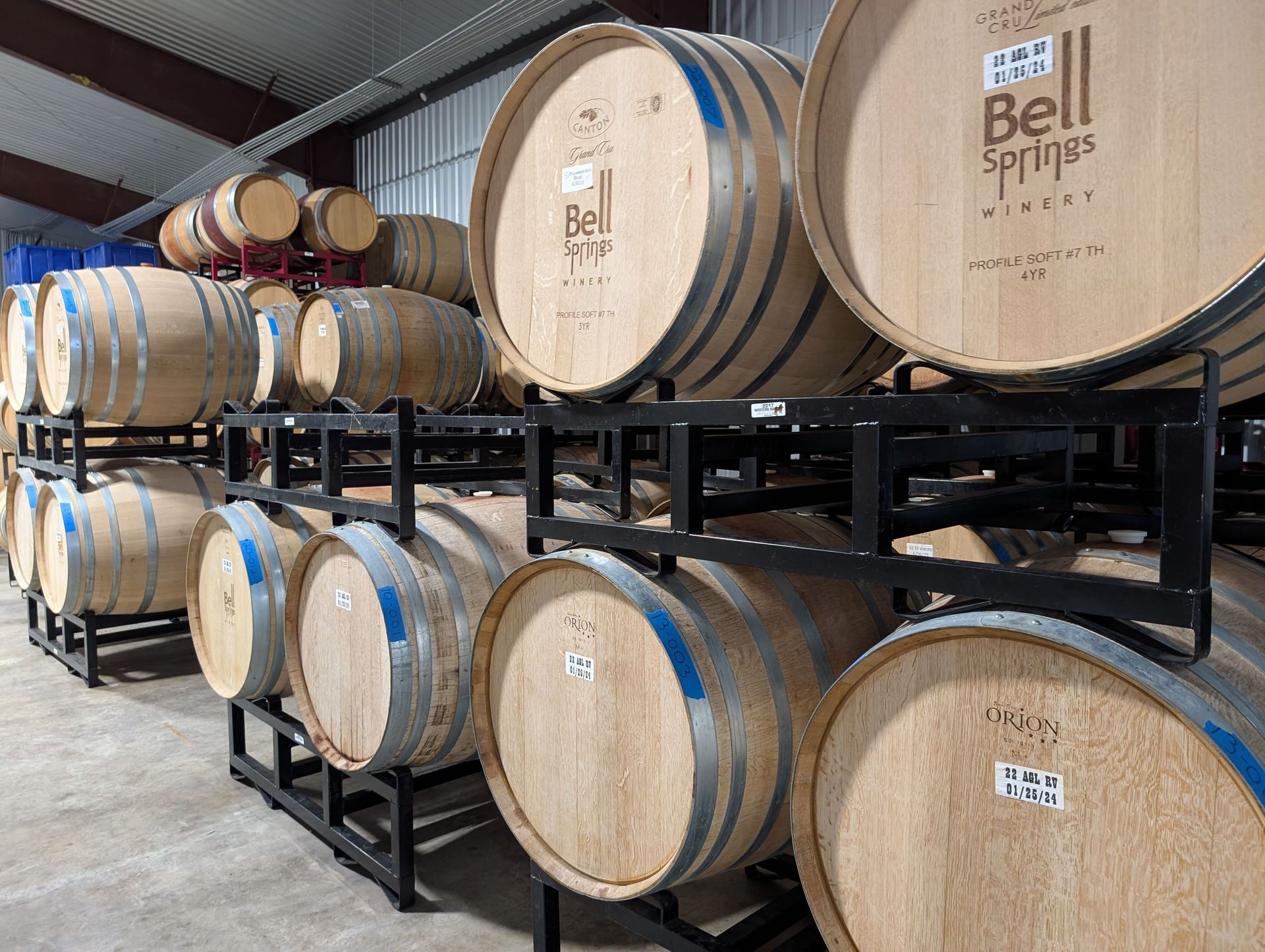 Wine barrels stacked in a cellar, labeled