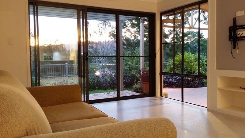 A Living Room With a Couch and Sliding Glass Doors — Kareela Constructions In Tamworth, NSW