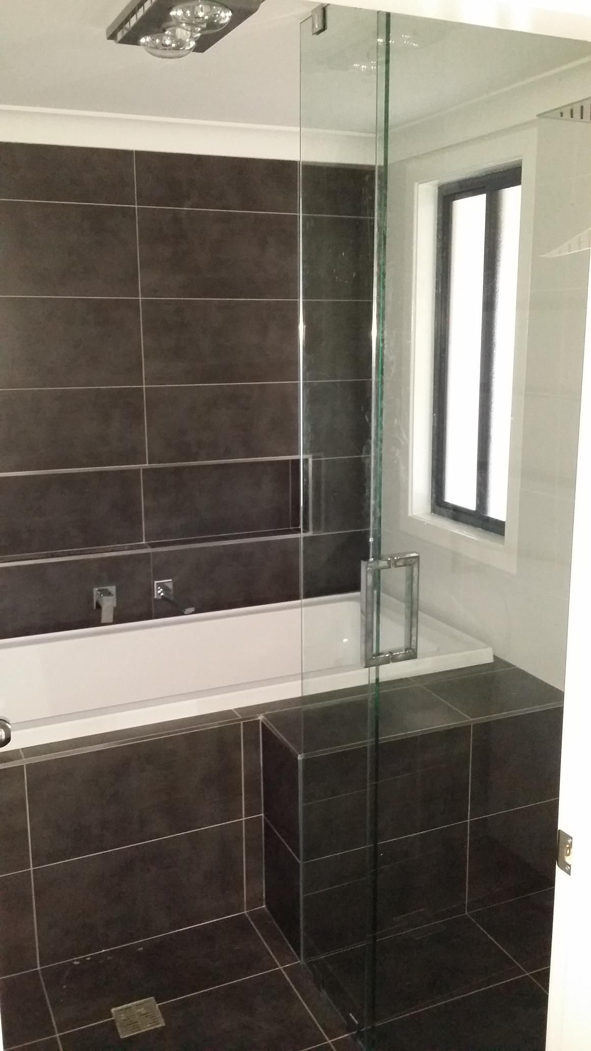 A Bathroom With a Bathtub, Shower, and Window — Kareela Constructions In Tamworth, NSW