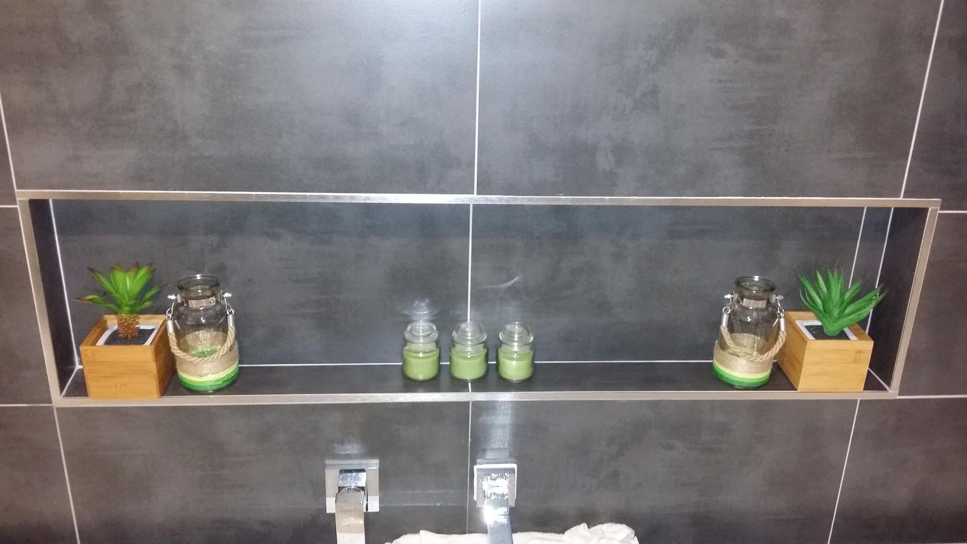 A Bathroom Shelf With Candles and Plants on It — Kareela Constructions In Tamworth, NSW