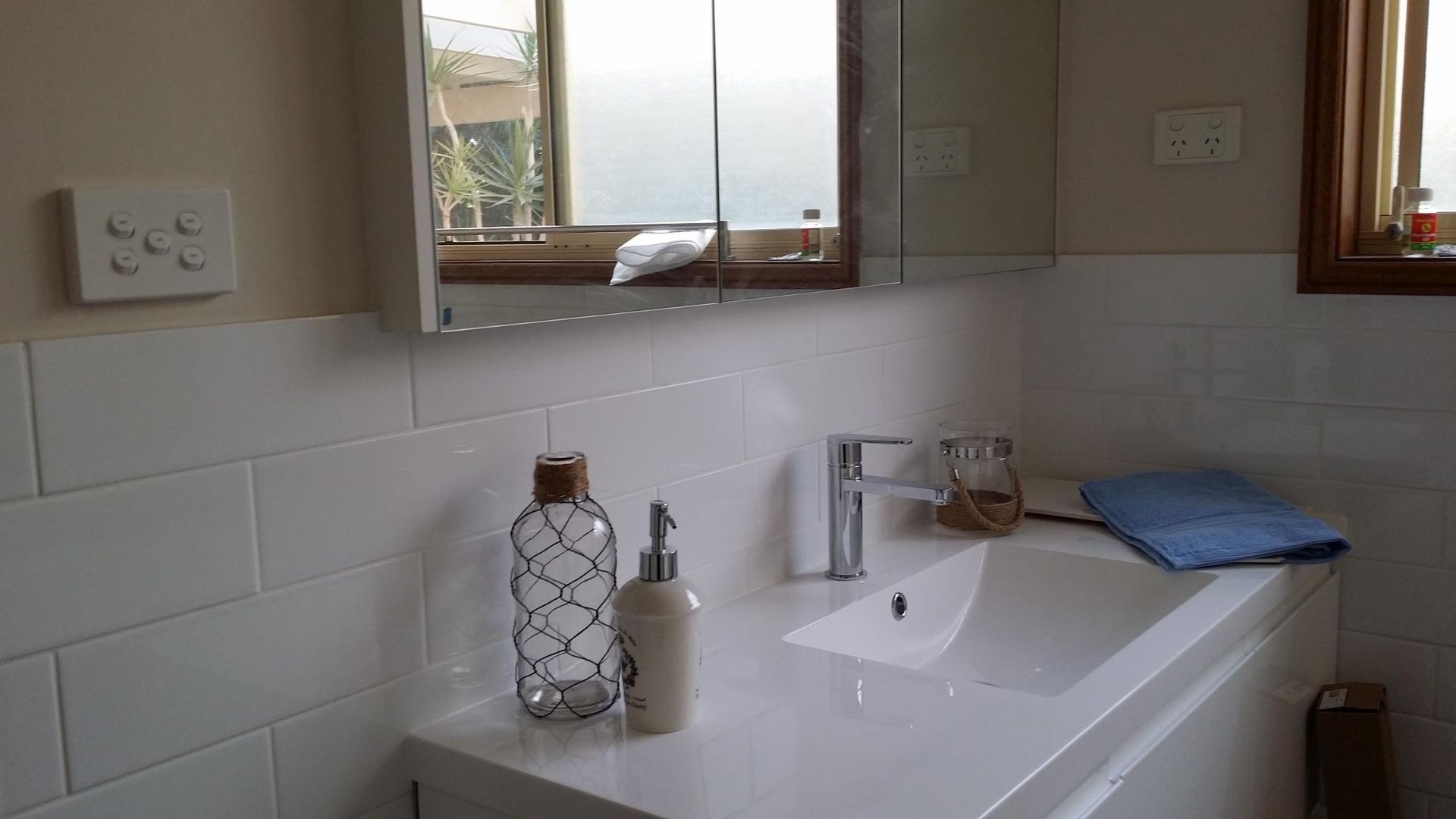 A Bathroom With a Sink, Mirror and Window — Kareela Constructions In Tamworth, NSW
