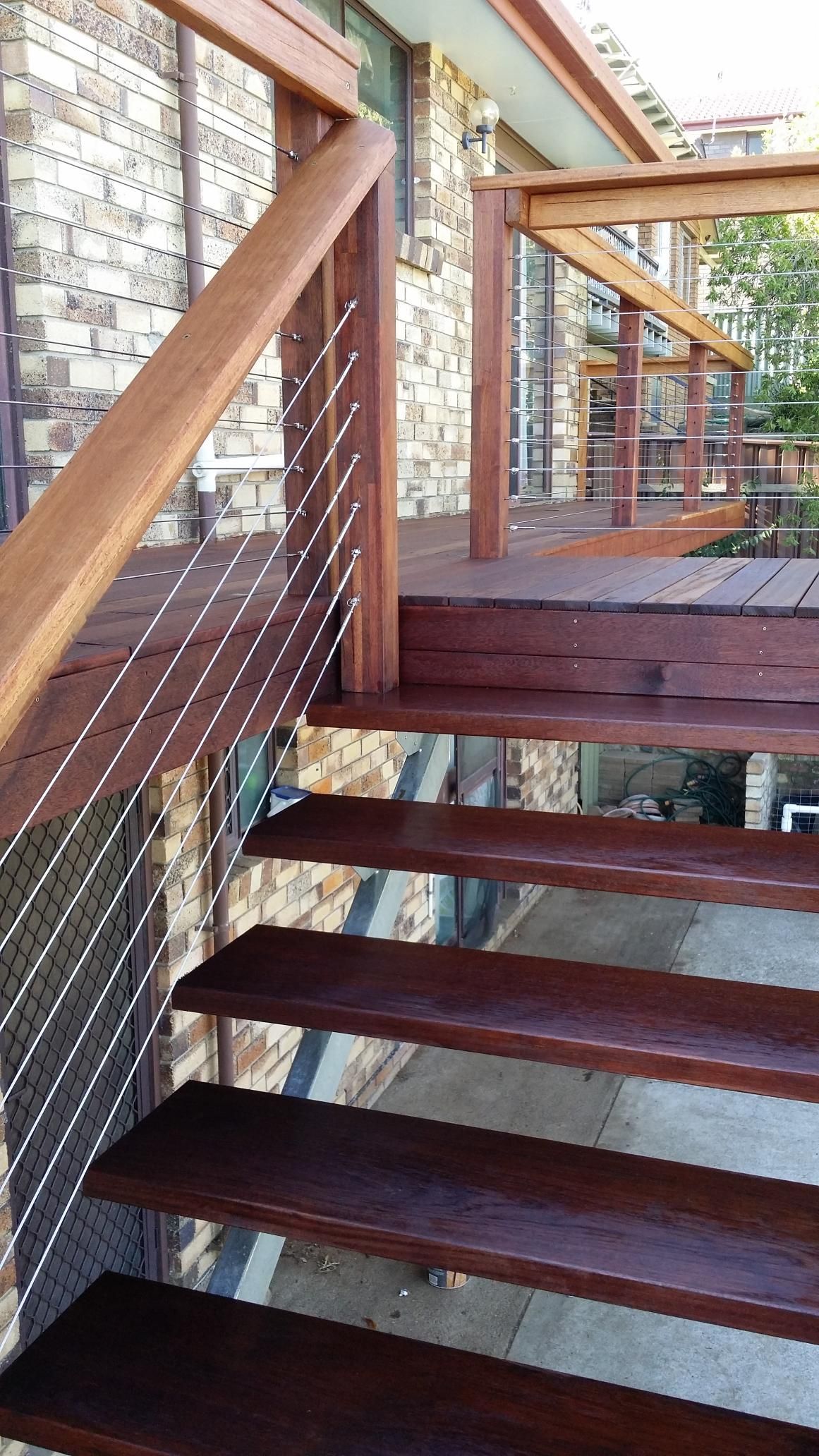 A Wooden Staircase With a Metal Railing is Leading Up to a Deck — Kareela Constructions In Tamworth, NSW