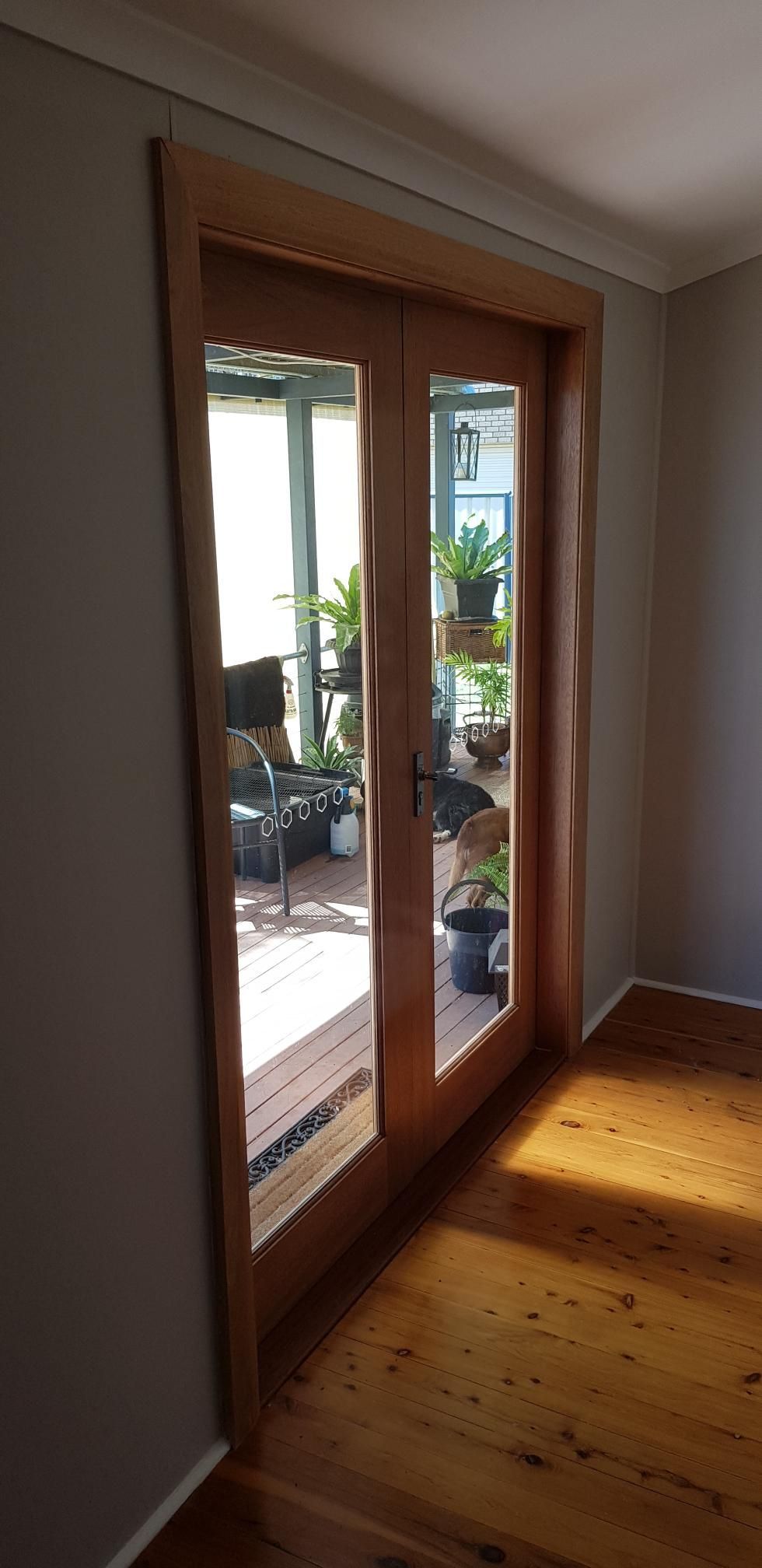 A Room With a Wooden Floor and Sliding Glass Doors Leading to a Balcony — Kareela Constructions In Tamworth, NSW