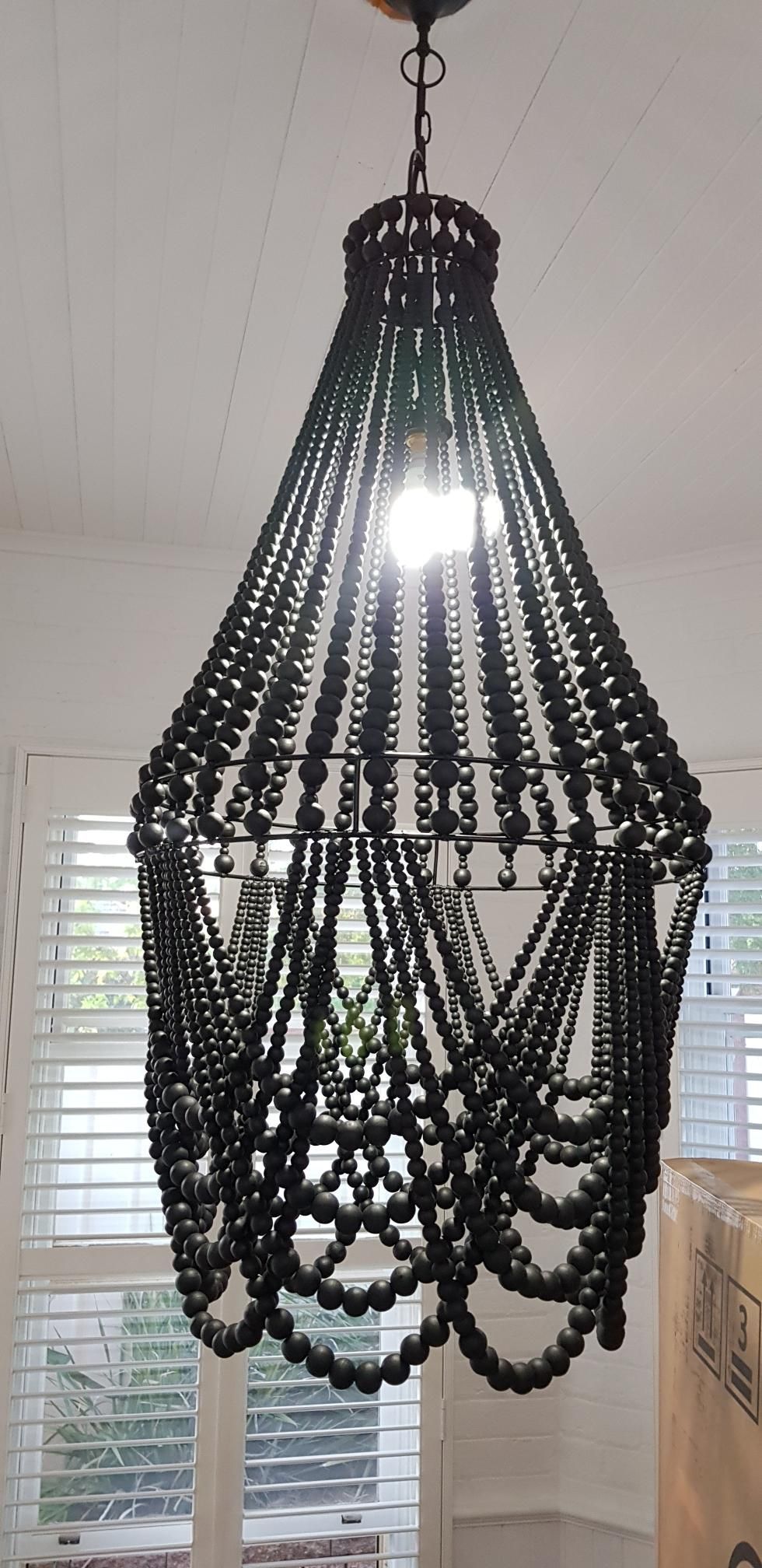 A Chandelier Made of Black Beads is Hanging From the Ceiling in a Room — Kareela Constructions In Tamworth, NSW