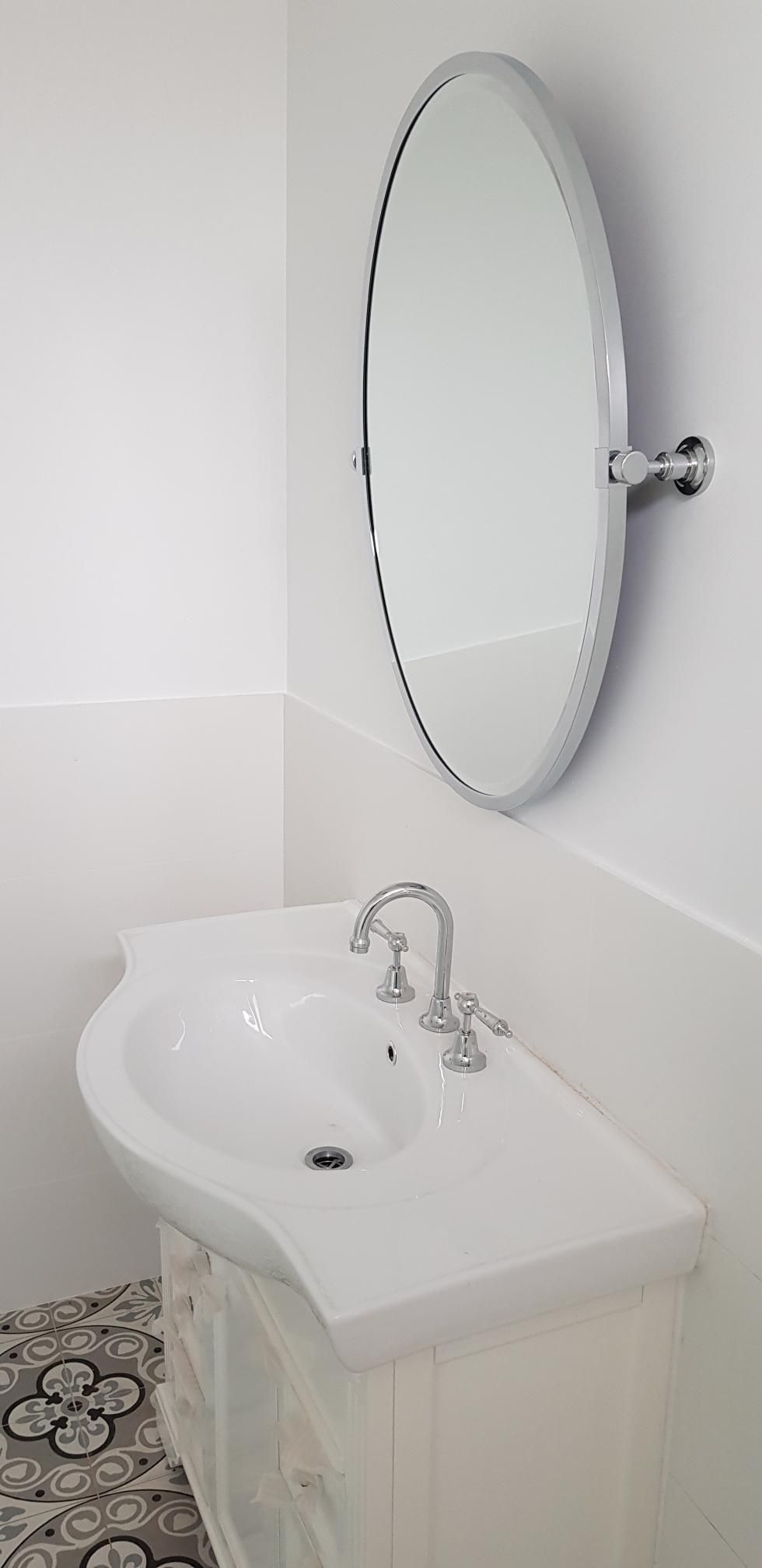 A Bathroom Sink With a Round Mirror Above It — Kareela Constructions In Tamworth, NSW