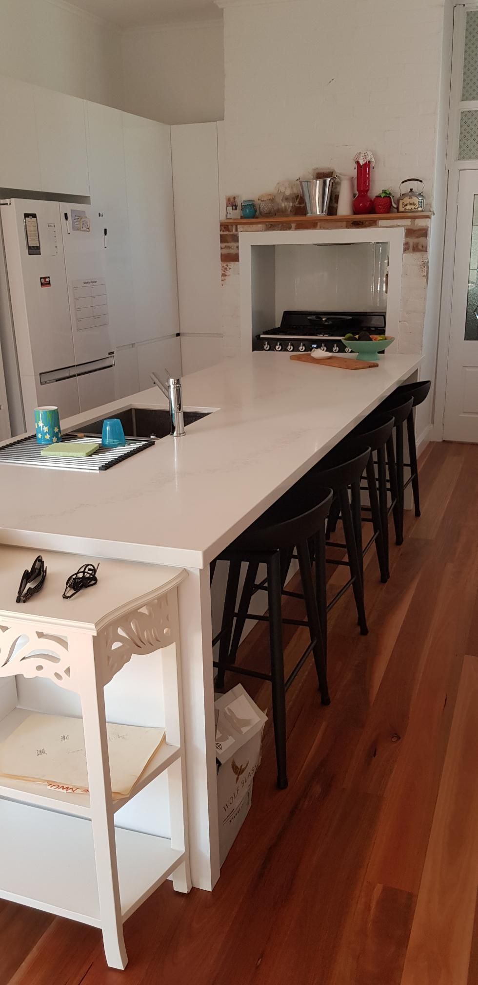 A Kitchen With a Large Island, Stools, a Sink and a Refrigerator — Kareela Constructions In Tamworth, NSW