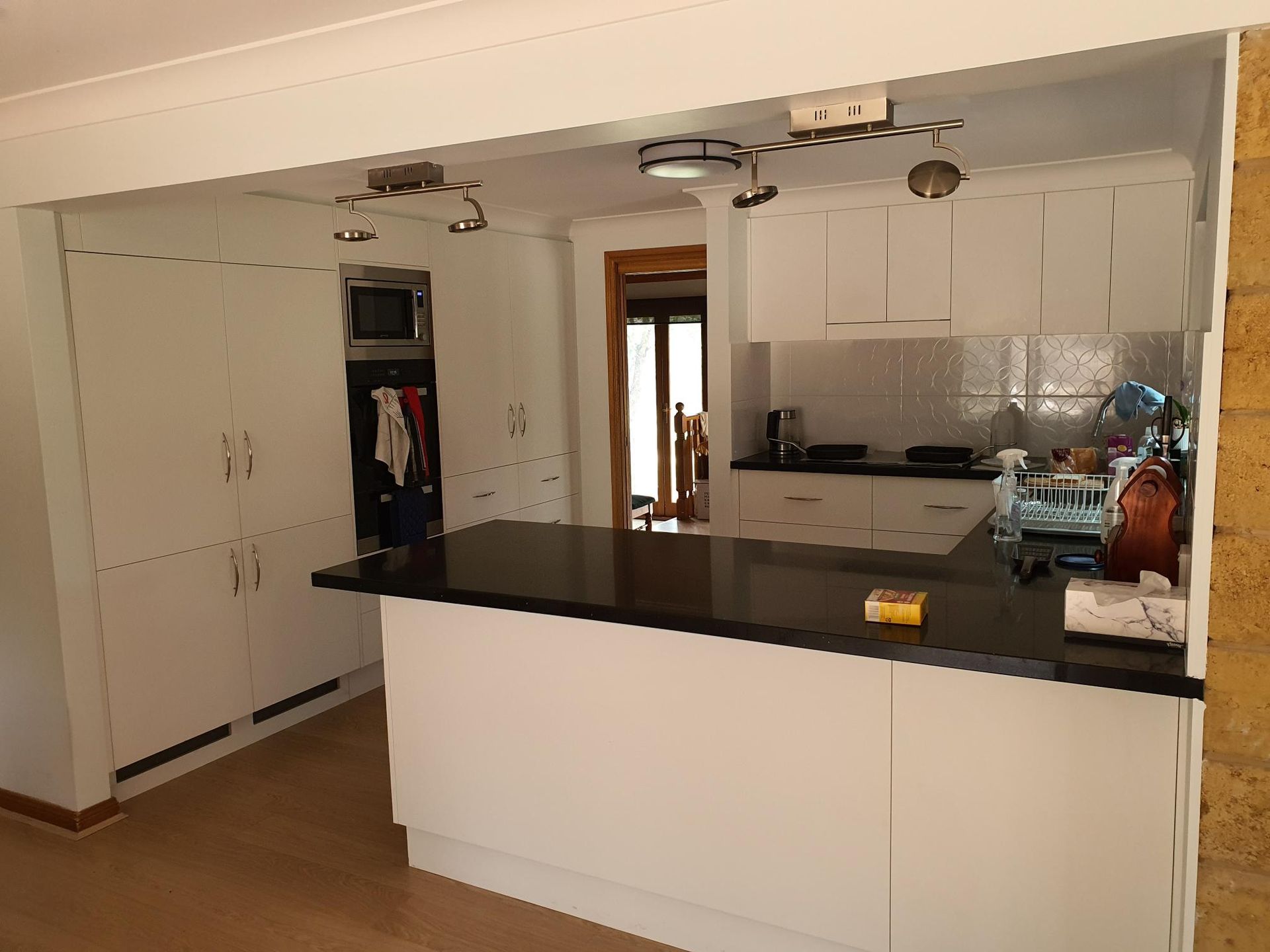 A Kitchen With White Cabinets and a Black Counter Top — Kareela Constructions In Tamworth, NSW
