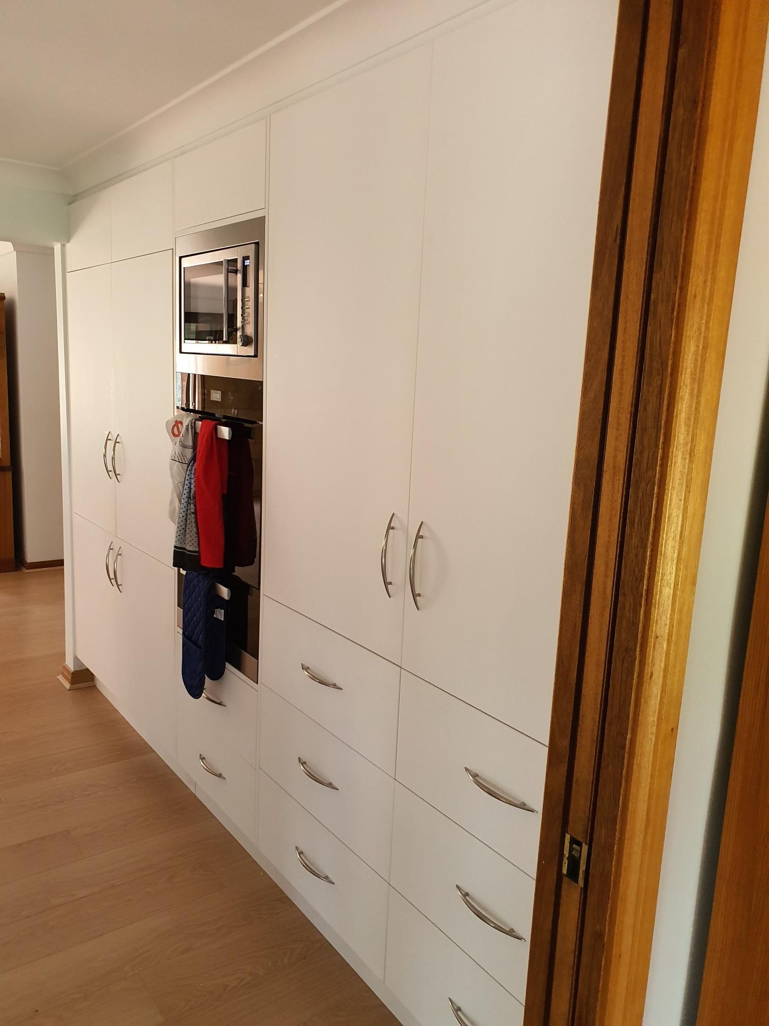 A Kitchen With White Cabinets and Drawers and a Microwave Oven — Kareela Constructions In Tamworth, NSW