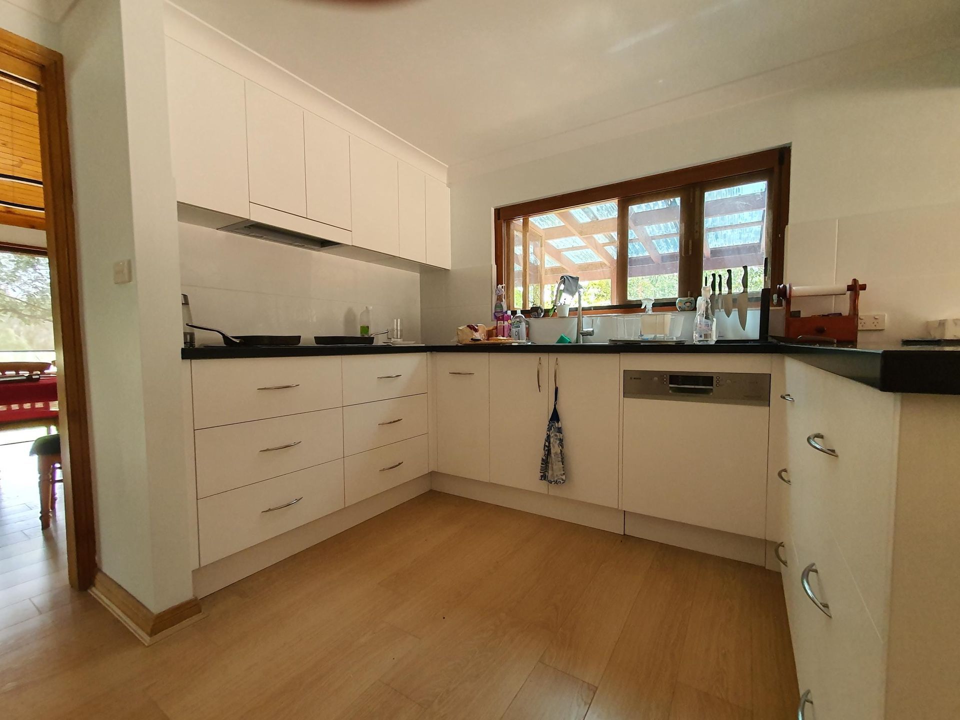 A Kitchen With White Cabinets and Black Counter Tops — Kareela Constructions In Tamworth, NSW
