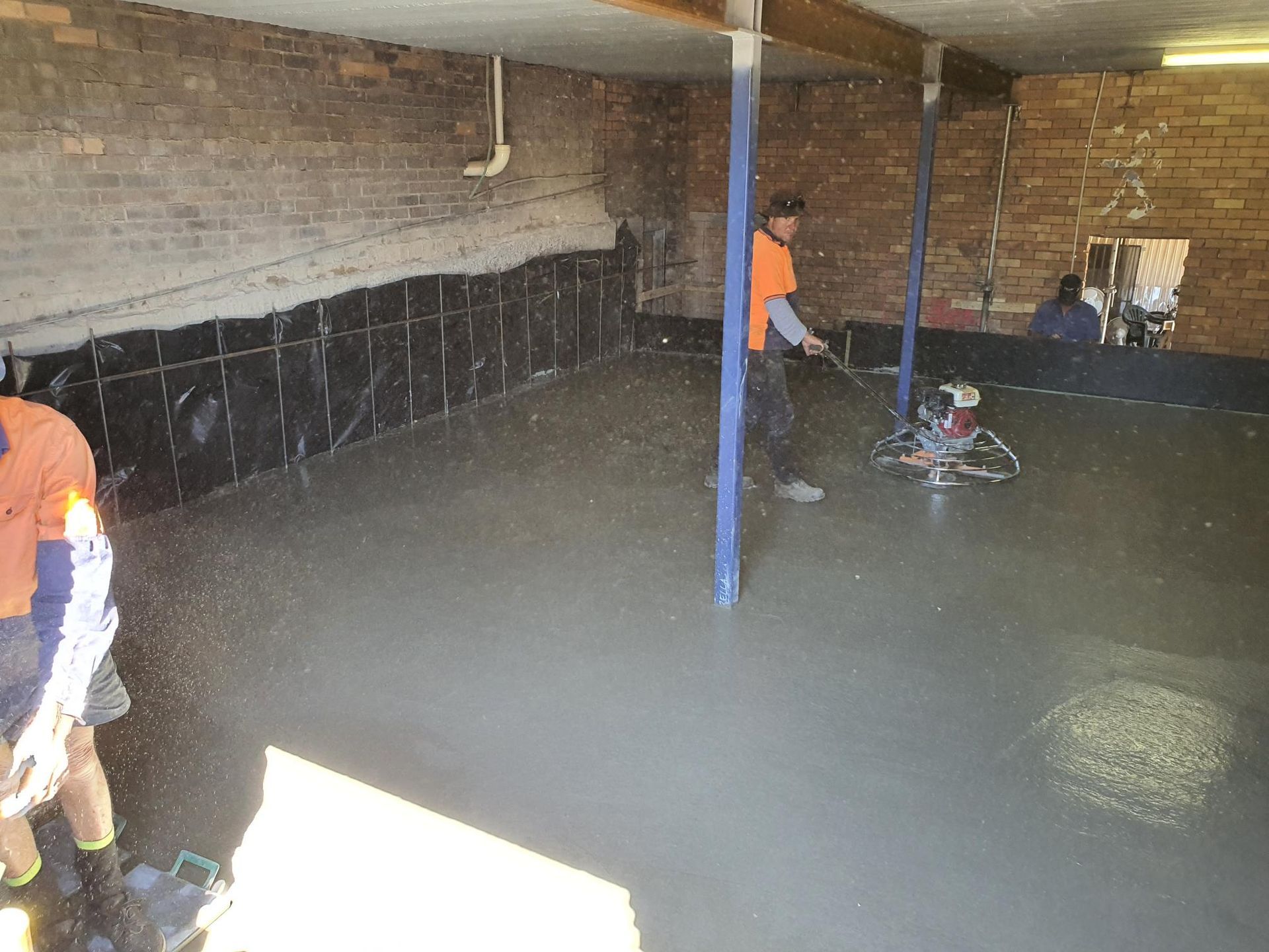 Two Men Are Working on a Concrete Floor in a Garage — Kareela Constructions In Tamworth, NSW