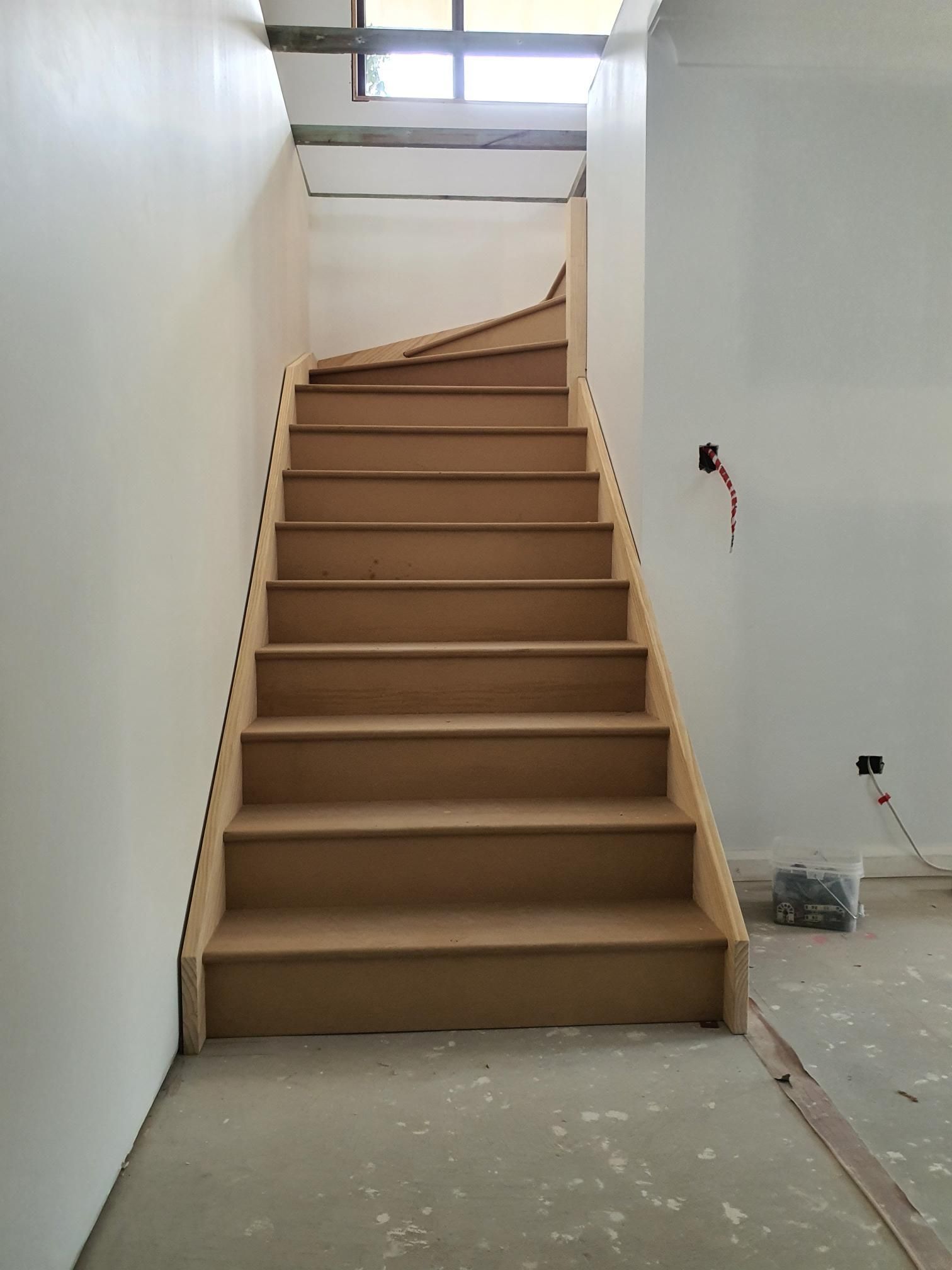 A Wooden Staircase is Being Built in a Room With White Walls — Kareela Constructions In Tamworth, NSW