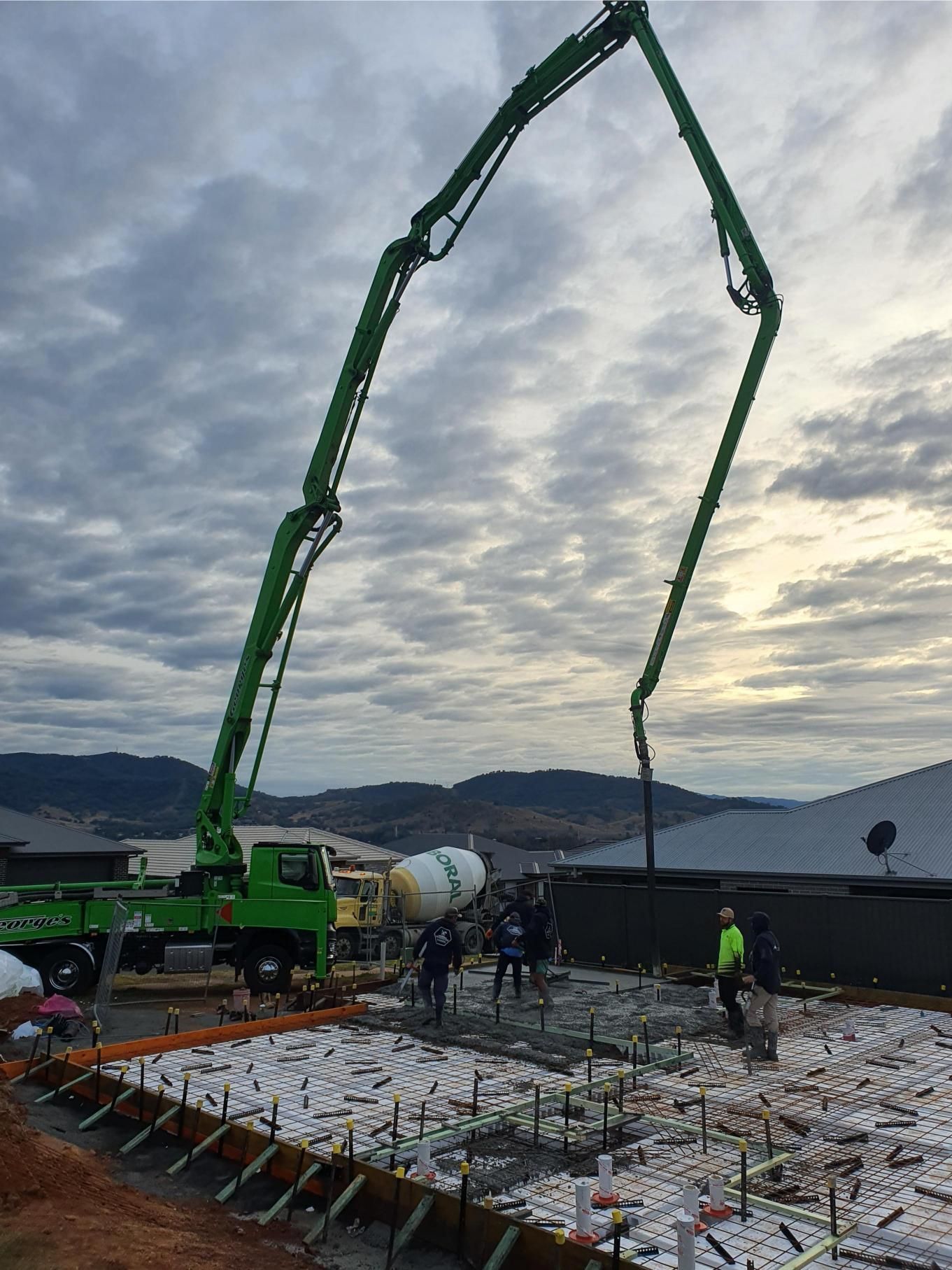A Green Concrete Pump is Pouring Concrete on a Construction Site — Kareela Constructions In Tamworth, NSW