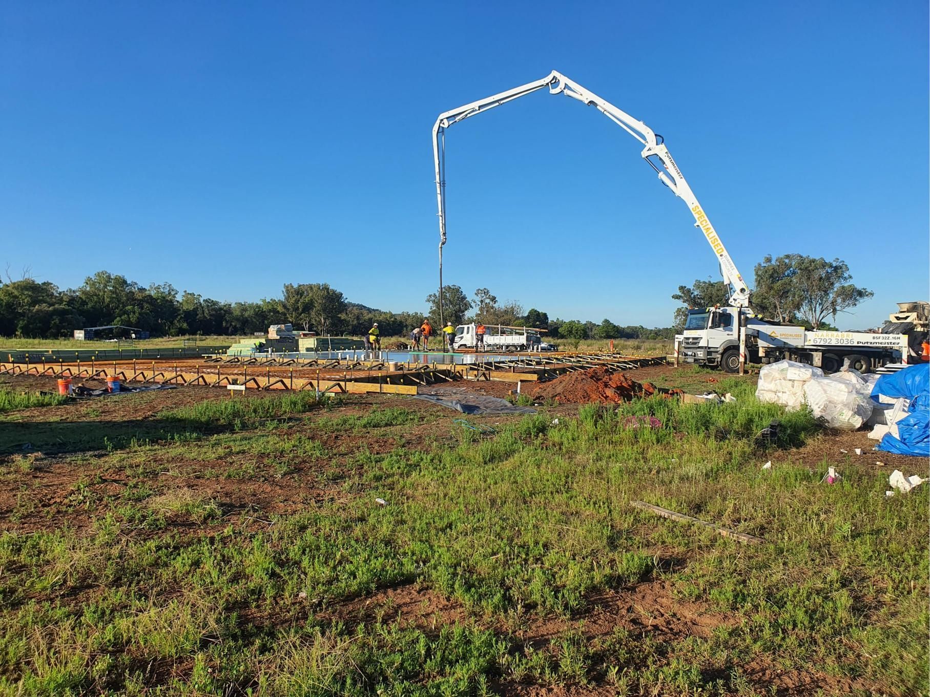 A Concrete Pump is Being Used to Pour Concrete Into a Field — Kareela Constructions In Tamworth, NSW