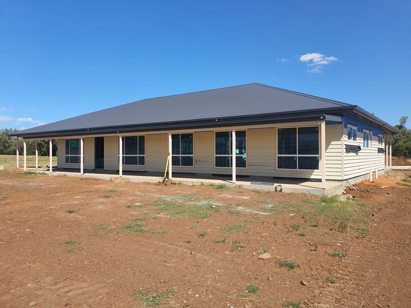 A Large House With a Black Roof is Sitting in the Middle of a Dirt Field — Kareela Constructions In Narrabri, NSW