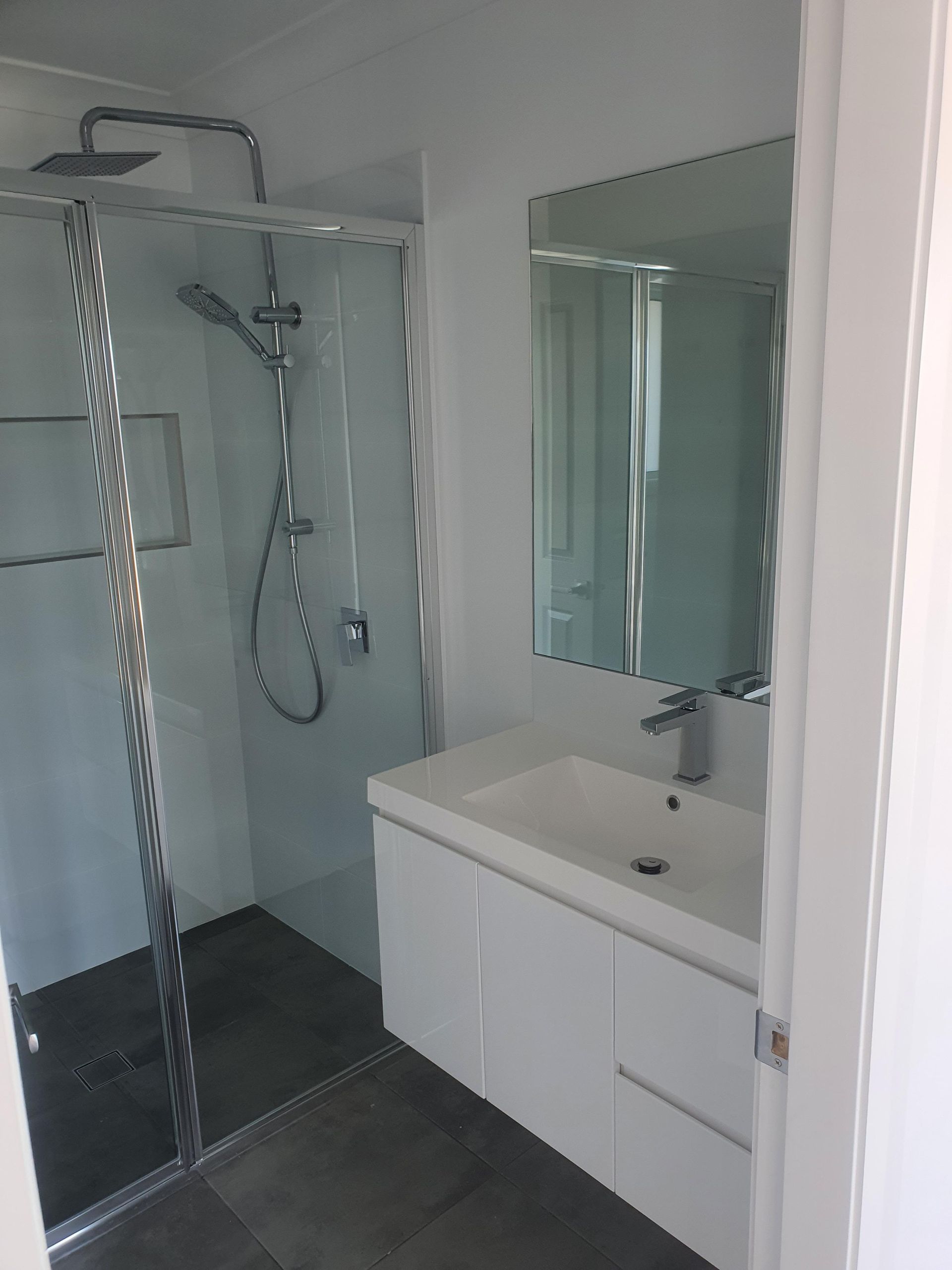 A Bathroom With a Sink, Shower and Mirror — Kareela Constructions In Tamworth, NSW